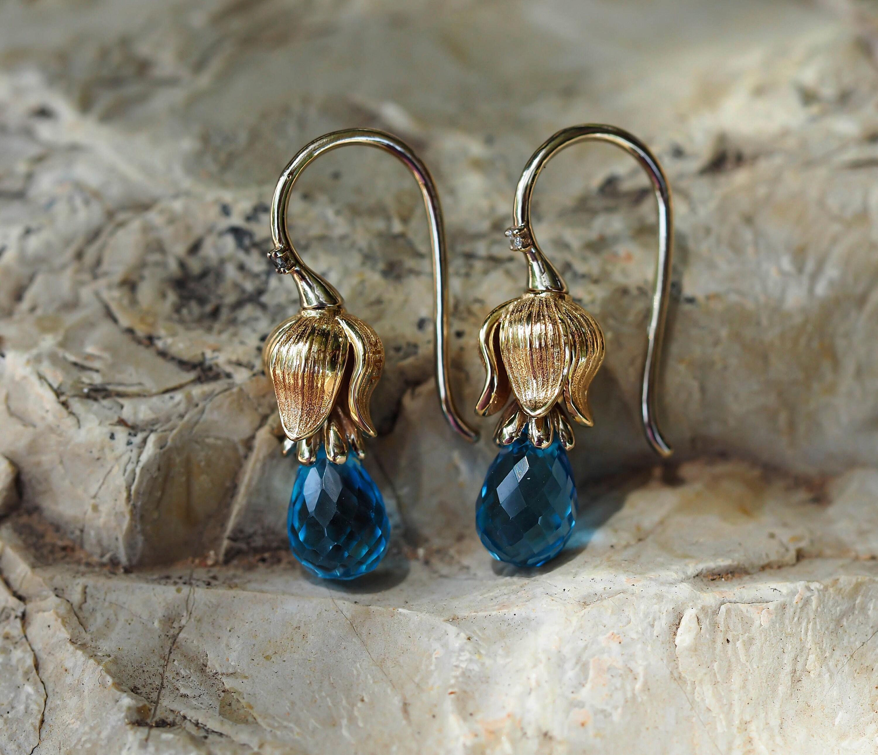 Lily flower earrings with topazes and diamonds.

Metal: 925 silver
Weight: 3.25 g.
Size: 21x6mm.

Topazes 2 pieces - sky blue color, briolette cut, transparent, 8.5x5.7 mm each, aprx 3 ct total.
Diamonds 2 piece, 0.02 total ct, G/VS, brilliant