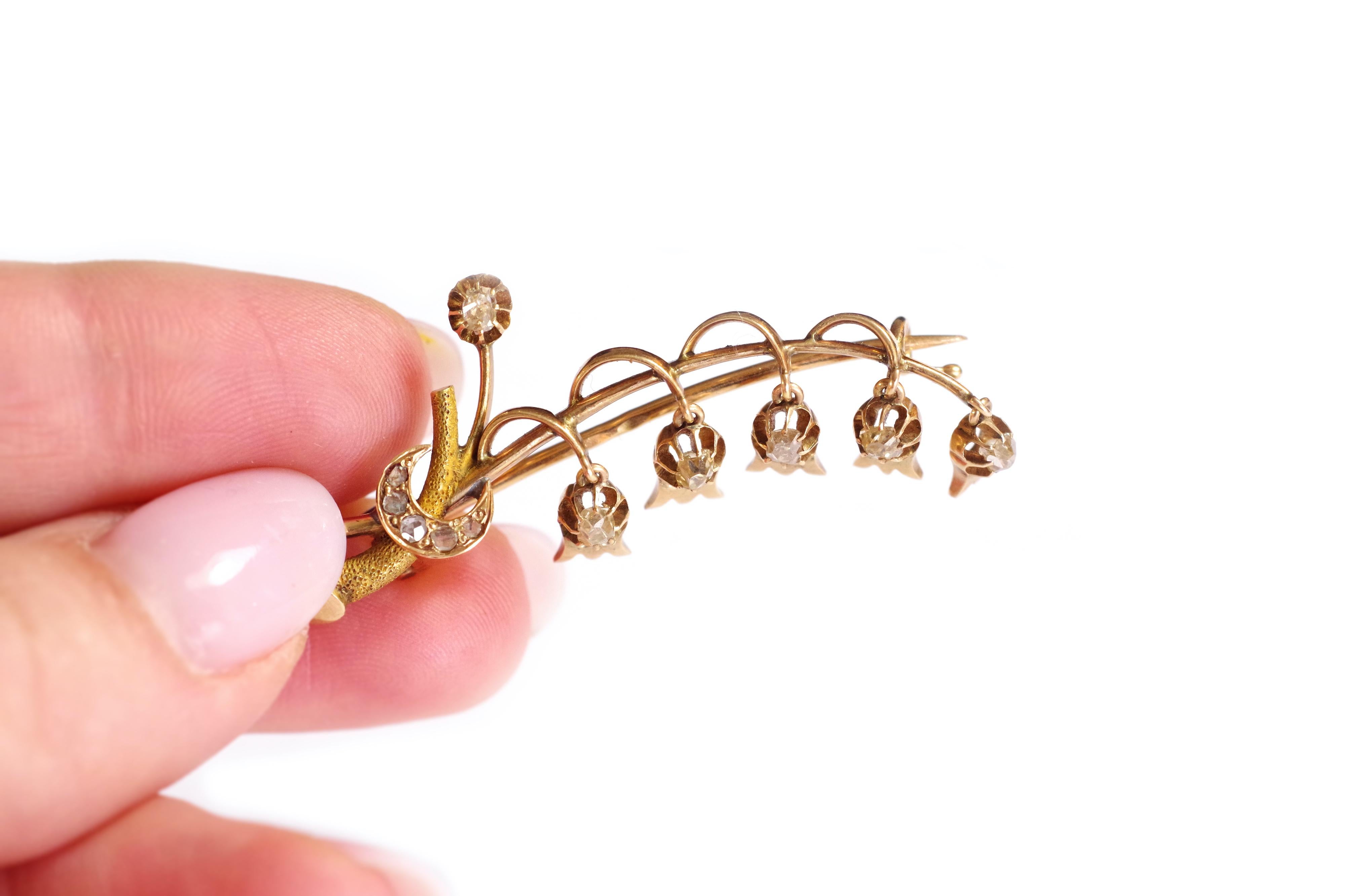 Broche ruso Lirio de los valles en oro rosa y amarillo de 14 quilates. El broche representa un ramito de lirio de los valles florecido con cinco campanillas adornadas con diamantes talla antigua. Las campanas son móviles. El comienzo del tallo está