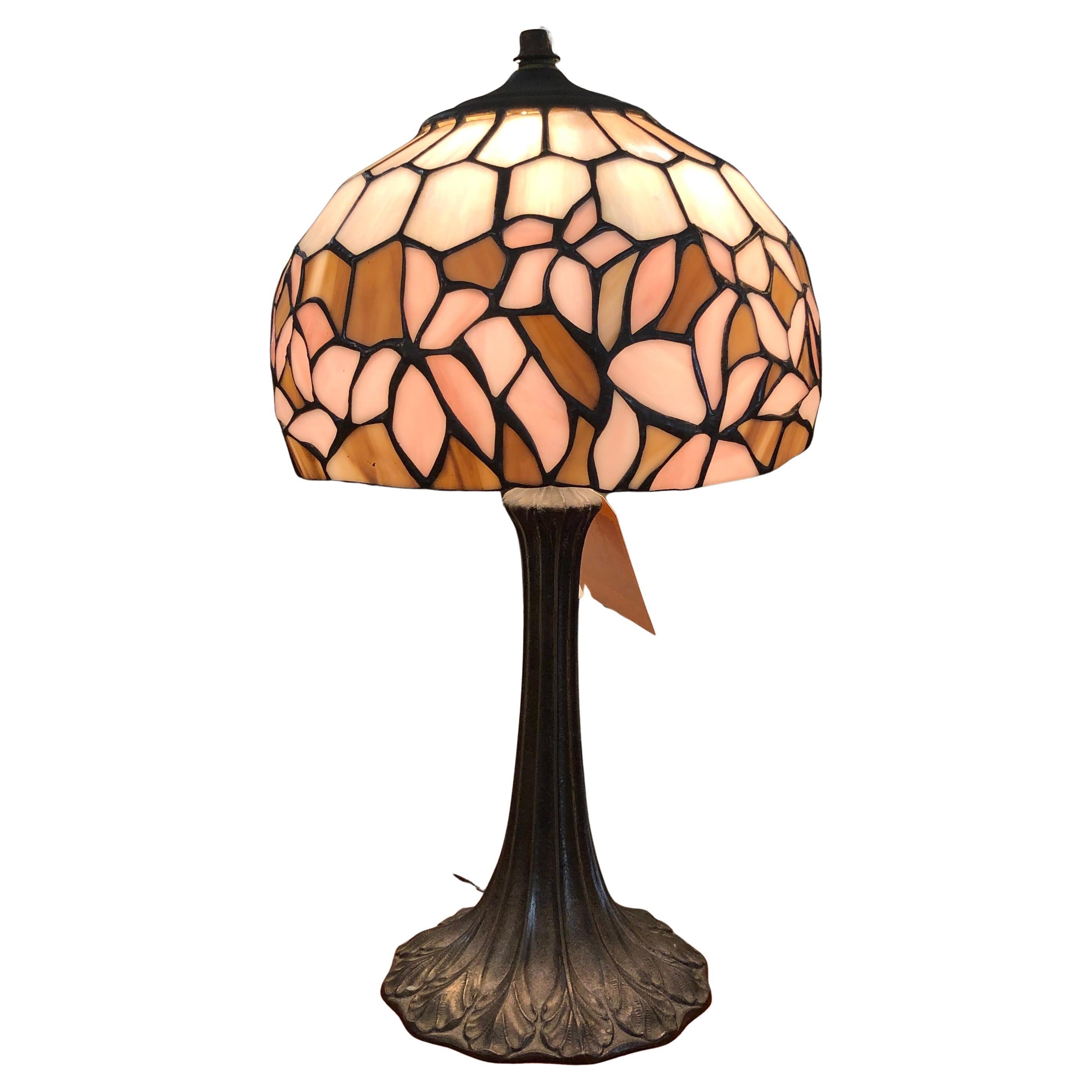 Petite table lamp with stained glass shade. Featuring muted lily pedals around the mosaic glass dome shade. Stamped with MORGAN underneath the metal base. John Morgan & Sons was a leading stained glass lamp producer, out of Brooklyn NY.
Please