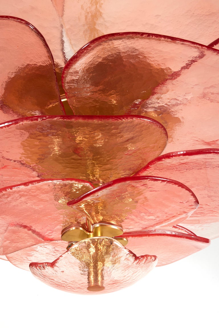 Textured glass chandelier composed of individuals pink petals mounted on a brass structure, in the shape of a lily pad flower that diffuses light. 
The chandelier is composed of 24 spotlights.
All is crafted in northen Italy near Venise.