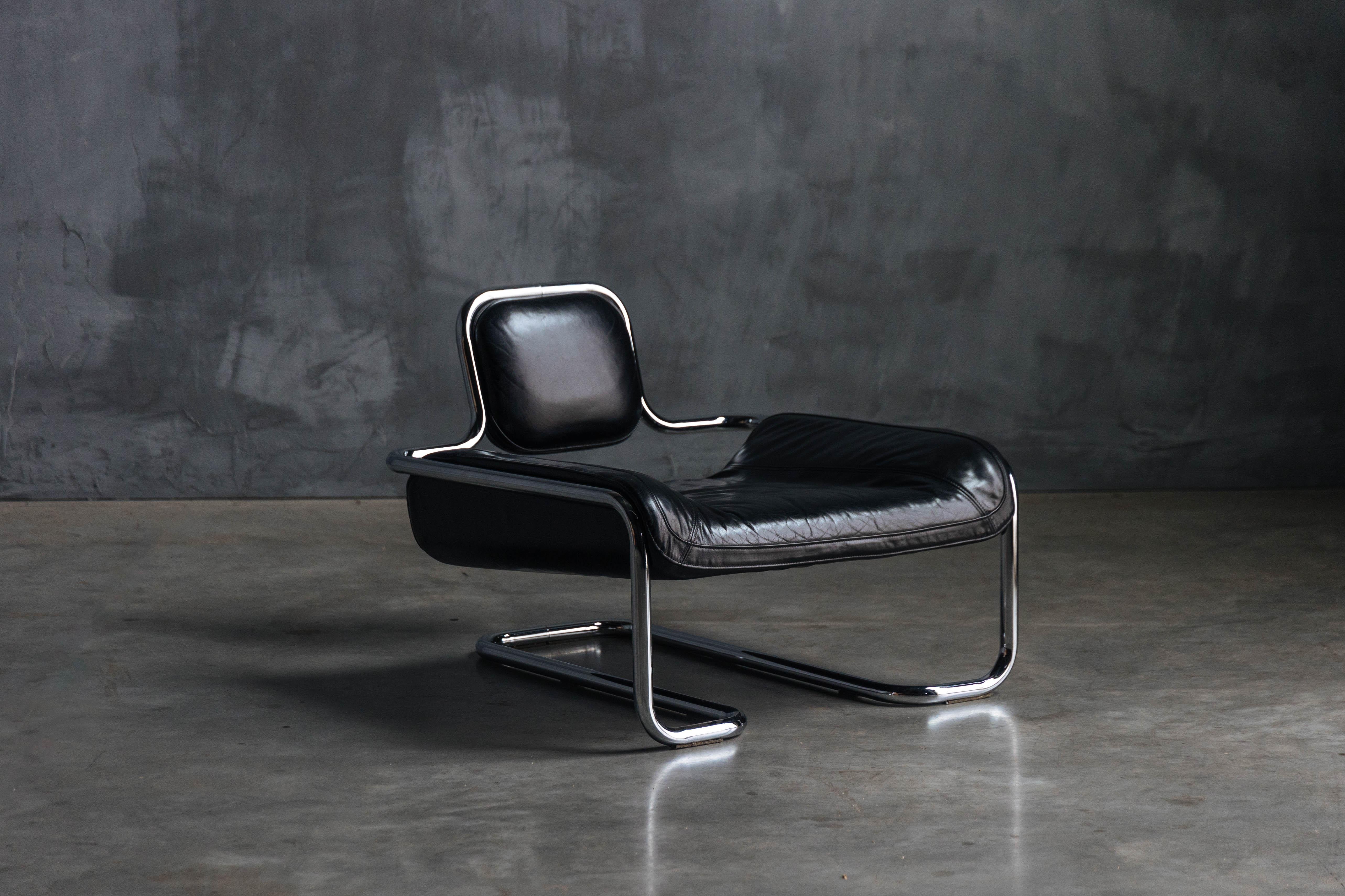 Rare low lounge chair, designed by Kwok Hoi Chan for Steiner in 1971, showcasing a striking combination of sleek design and comfort. Its thick chrome-plated tubular metal frame perfectly complements the rich black leather upholstery, which boasts a