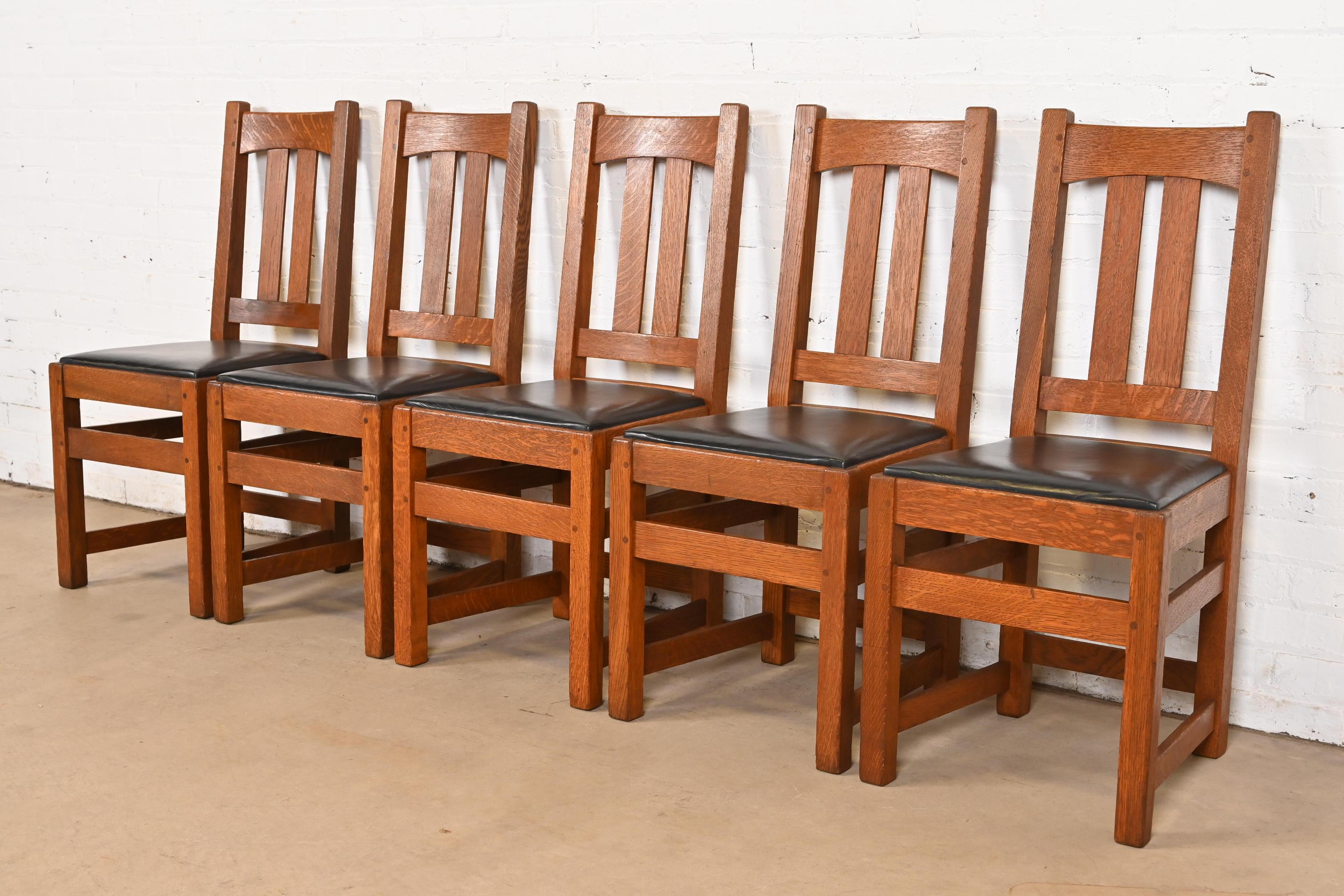 Un bellissimo set di cinque sedie da pranzo d'epoca Mission o Arts & Crafts

Di Charles P. Limbert Co.

USA, circa 1910

Telaio in massello di quercia segato a quarto, con sedili imbottiti in pelle.

Misure: 16,5