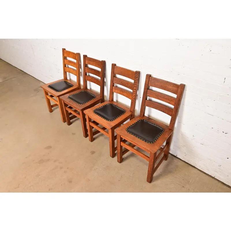 Un bellissimo set di quattro antiche sedie da pranzo con schienale a scaletta Mission o Arts & Crafts

Di Charles P. Limbert Co.

USA, circa 1910

Telaio in massello di quercia segato a quarto, con sedili rivestiti in pelle borchiata.

Misure: