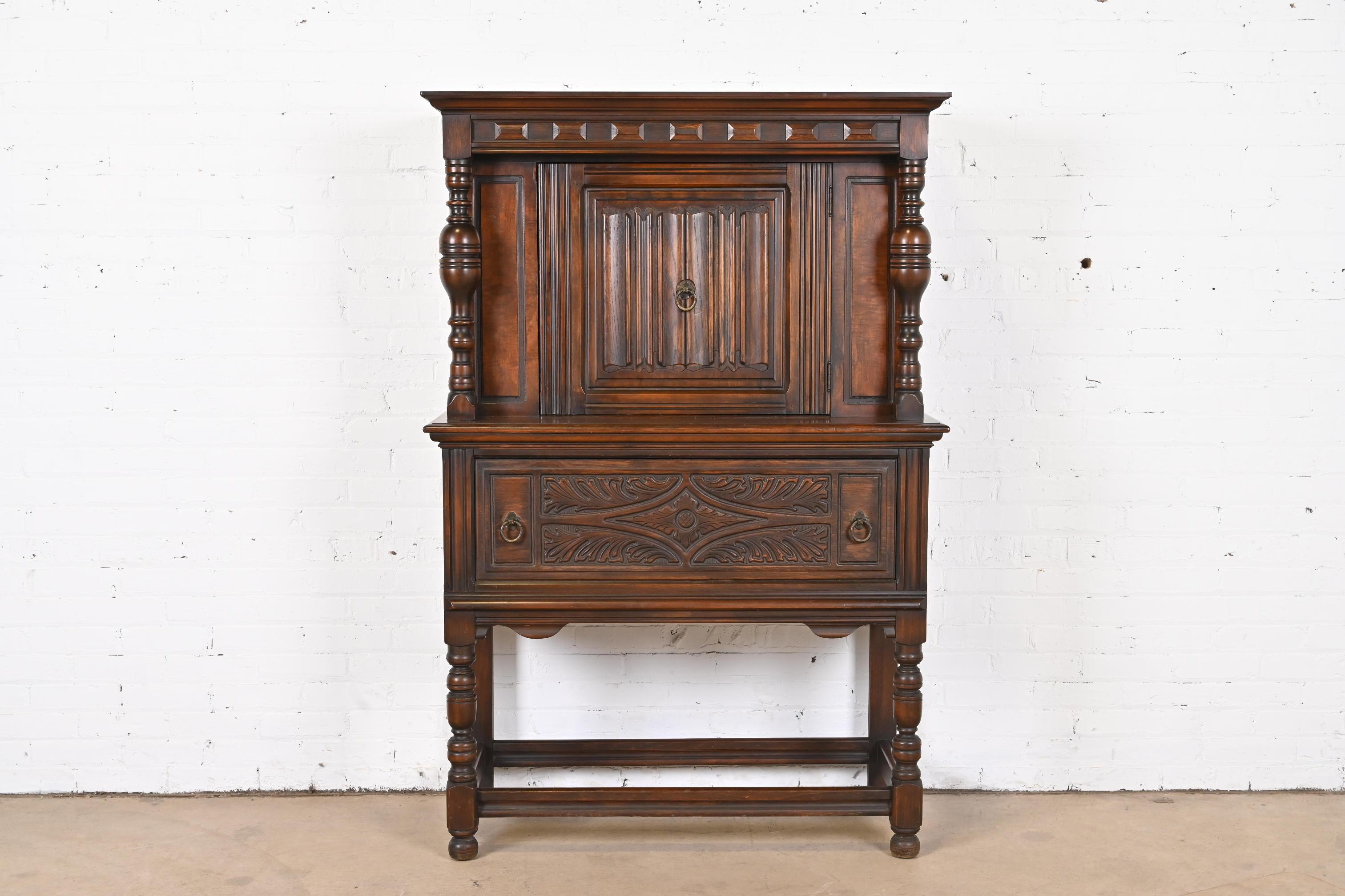 A gorgeous Tudor or Jacobean style china hutch or bar cabinet

By Charles P. Limbert Co.

USA, Circa 1920s

Carved walnut, with original brass hardware.

Measures: 42