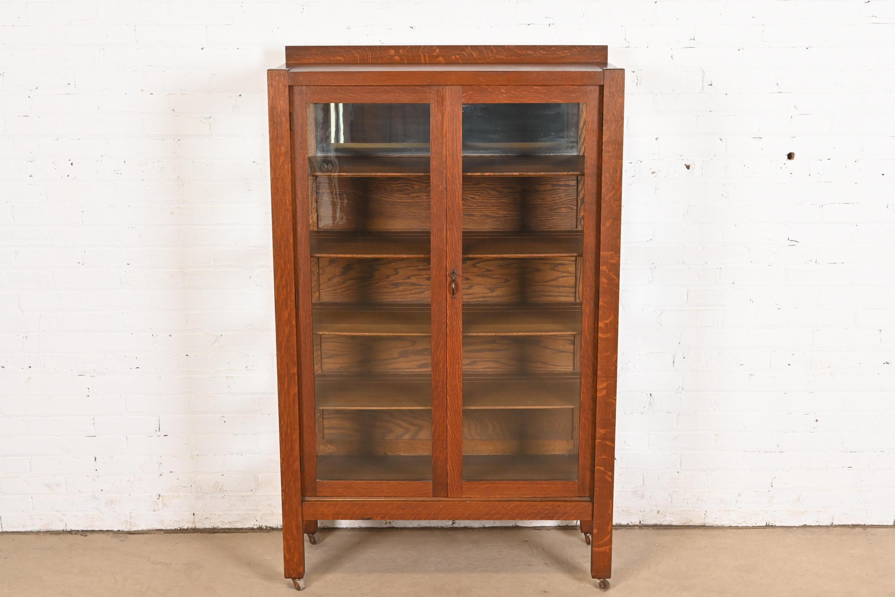 Un bellissimo mobile libreria o vetrina d'epoca Mission o Arts & Crafts

Alla maniera di Charles P. Limbert Co.

USA, circa 1900

Quercia segata in quarto, con porte e lati anteriori in vetro, interno superiore a specchio e ferramenta originale in