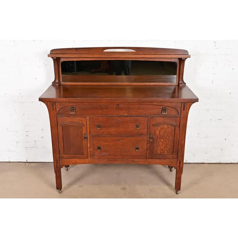 Un'eccezionale credenza d'epoca Mission o Arts & Crafts, un buffet o un mobile da bar

Alla maniera di Charles P. Limbert Co.

USA, circa 1910

Quercia segata a un quarto, con ferramenta originale in rame e retrospiaggia a specchio.

Misure: 56 