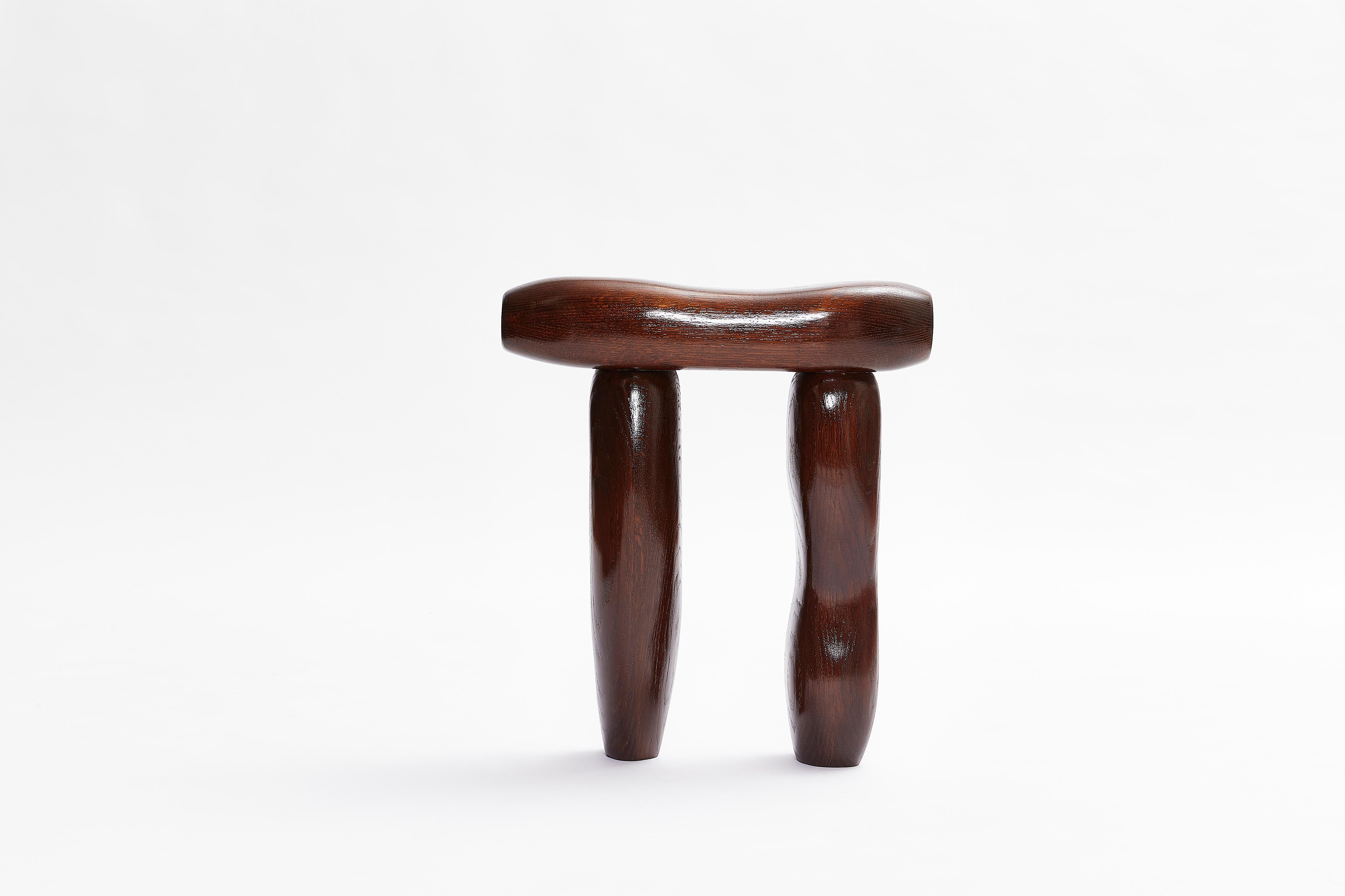 A narrow stool setting of three disjointed forms, pressed against one another. To be used whenever one needs to sit with their thoughts. Made from tinted American Oak. From Hard Candy series.

TSBTD (The Stone by the Door) was founded in
