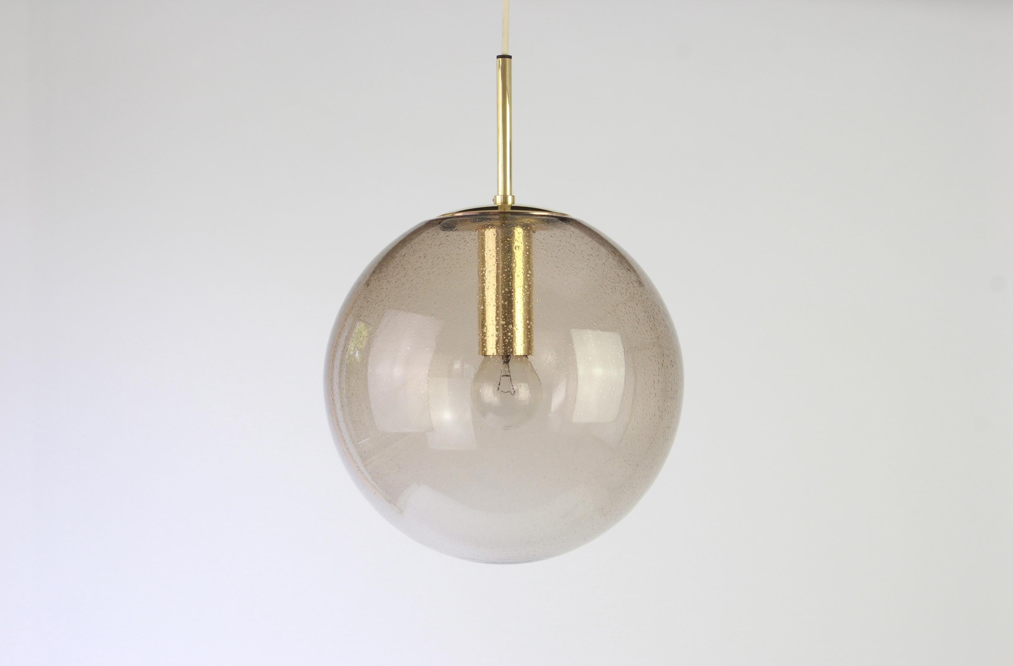 Large smoked glass ball pendant, manufactured by Limburg, Germany, circa 1970-1979.

Sockets: One x E27 standard bulb and compatible also with the US standards
with white or black cord.
Measures: Diameter 30 cm // 12 inches
Height (adjustable