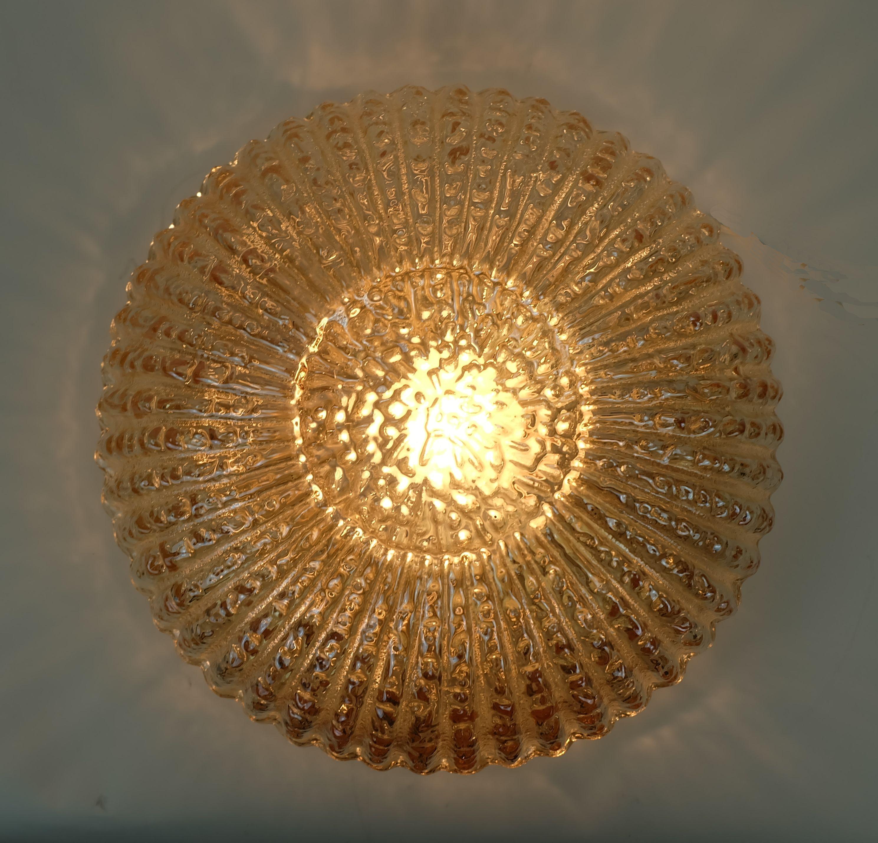 Lampada da soffitto di metà secolo prodotta negli anni '70 da Glashuette Limburg. Model A669. Il paralume è realizzato in vetro trasparente strutturato con una leggera tonalità ambrata. Base in metallo, interno color argento ed esterno color oro.