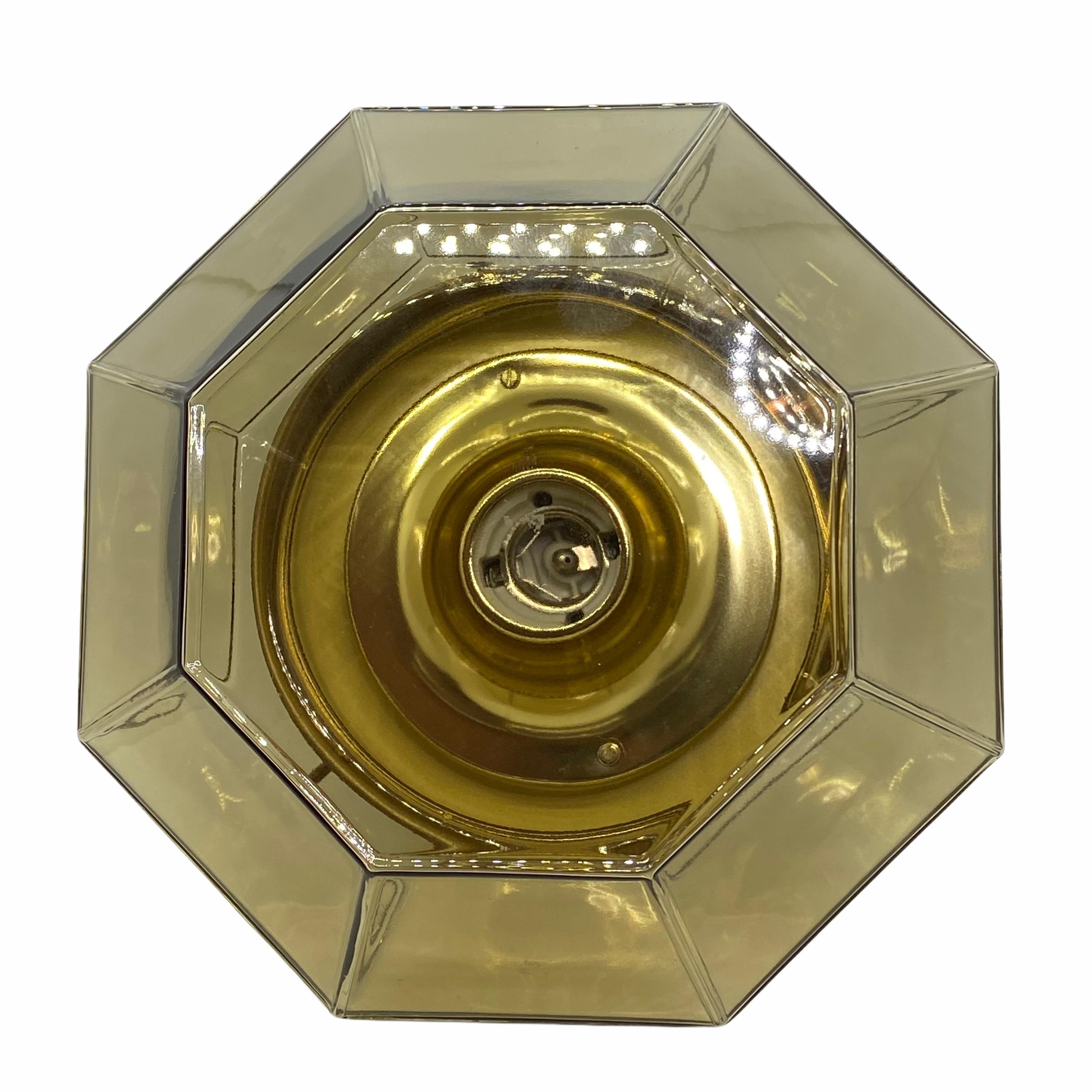 A beautiful large flush mount by German manufacturer Glashuette Limburg. The large geometric glass element is supported by a polished brass plate with one light sources. Beautiful diamond shaped glass on a metal fixture. The Fixture requires one