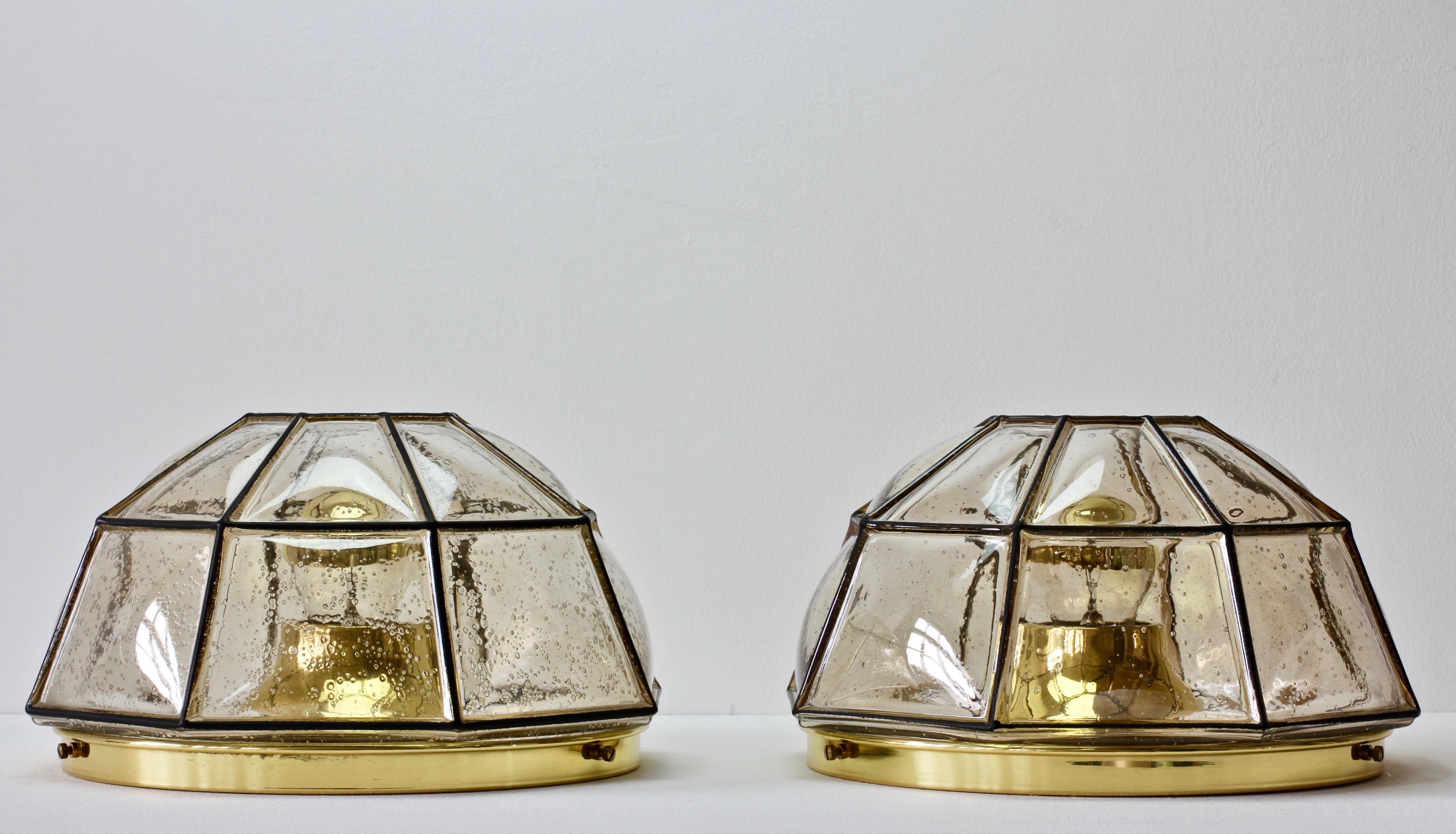 Glashütte Limburg vintage midcentury pair of minimal, geometric and elegant mouth blown clear glass - with a slight champagne / topaz tone - and polished brass wall or ceiling flush mount lamps or light fixtures / sconces made in Germany, circa