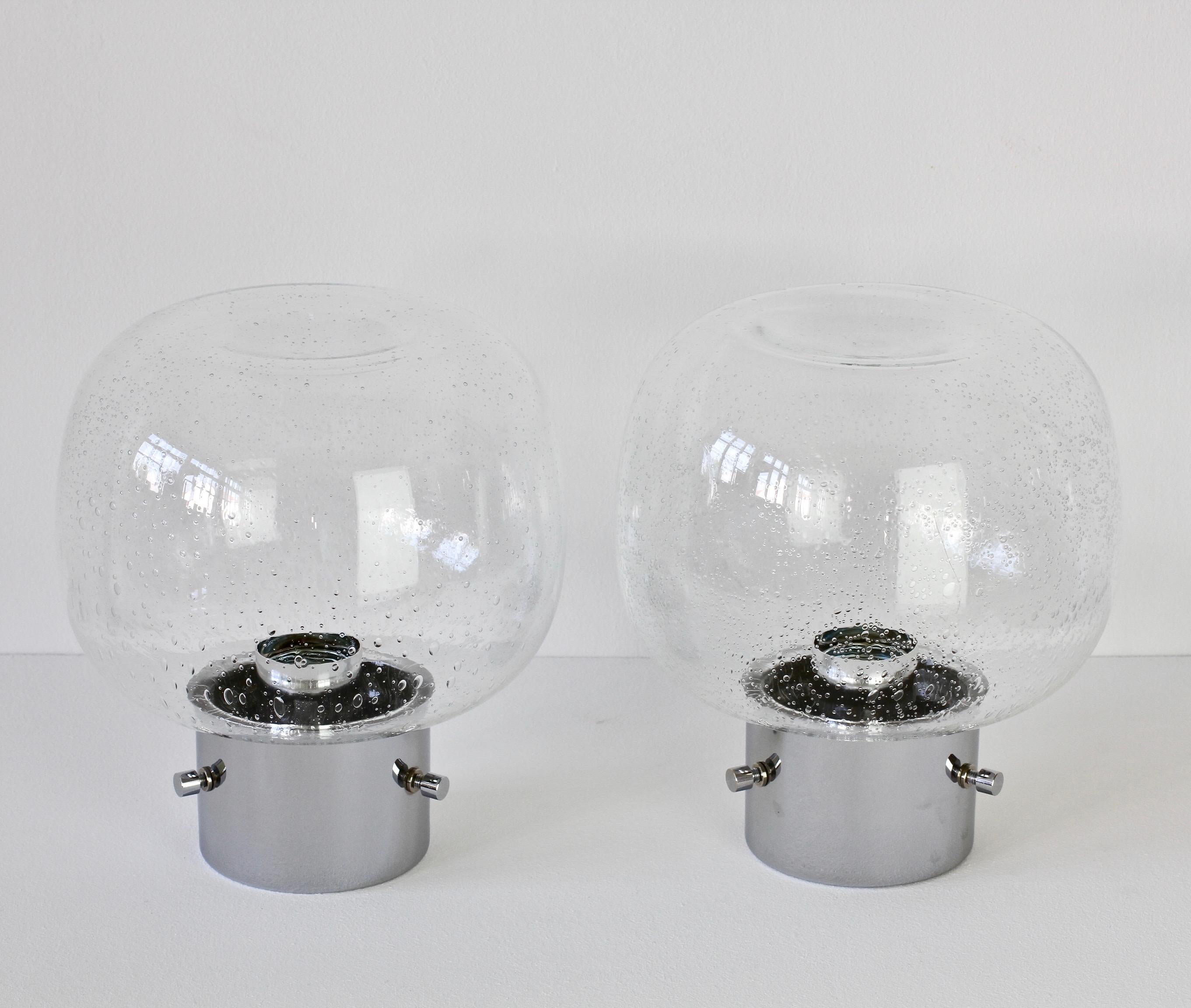 Refurbished pair of vintage German made late Mid-Century Modern wall or ceiling flush mount lights produced by Glashütte Limburg, circa 1975. Featuring a round domed mouth blown bubble glass shade and a polished chrome mount. Being mouth blown each