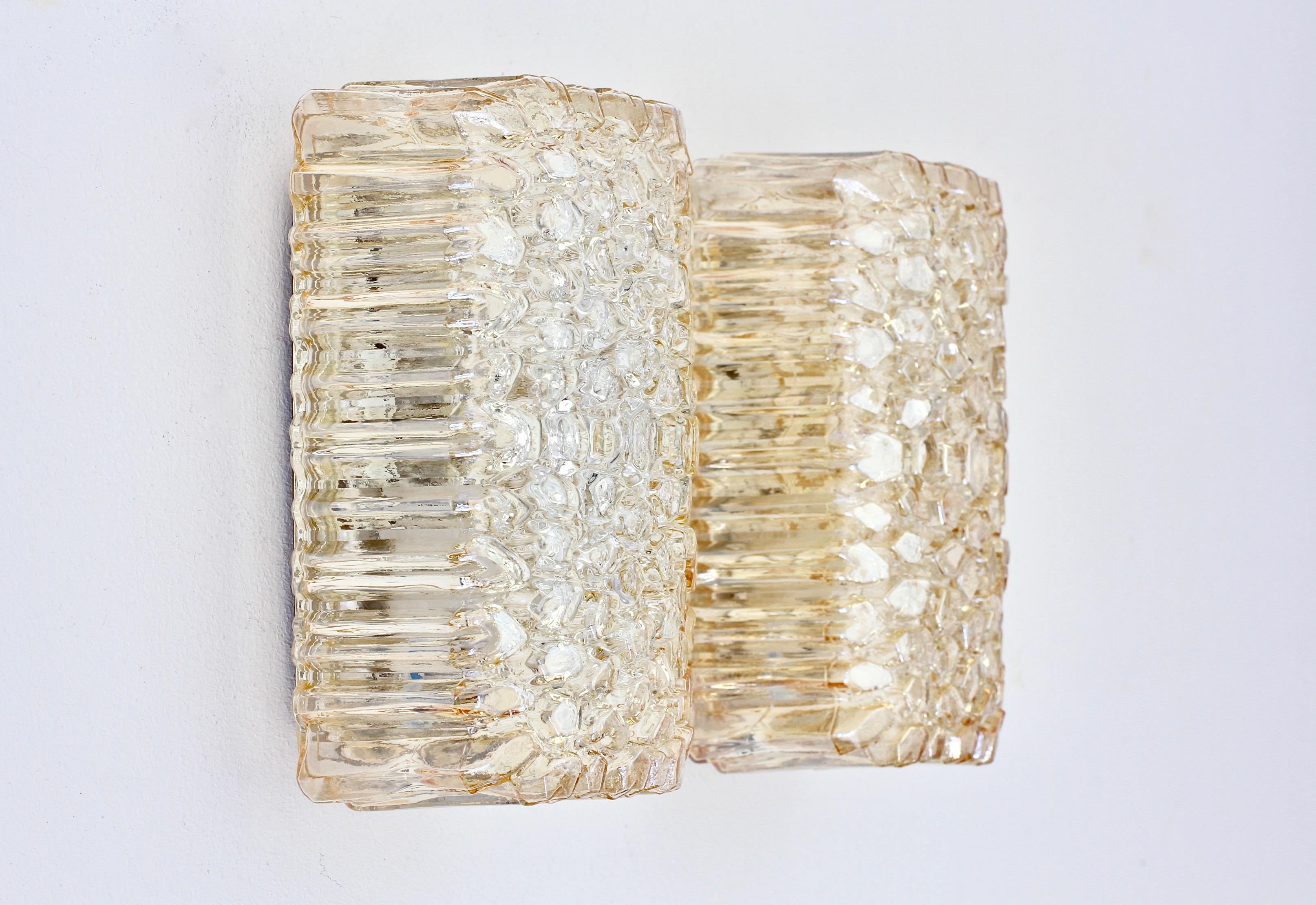 Limburg Glashütte pair of flush mount light fixtures or wall-mounted sconces, circa 1970s. Featuring wonderful German made mouth blown, molded and textured champagne colored or amber toned glass shades resembling ice crystals. These midcentury