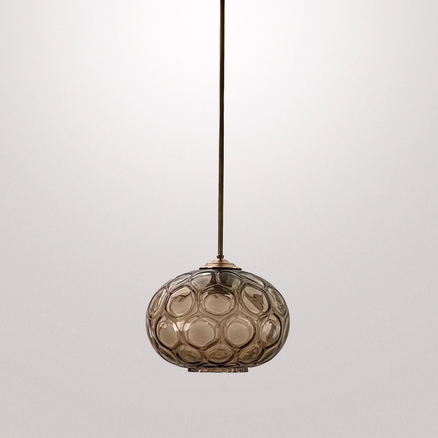 Limburg smoked glass honeycomb pendant light
Germany, circa 1960s
hand blown smoked amber glass globe
Rich with texture, swirls and honeycomb pattern
Resembles sacred geometry
Brass stem and canopy
Patina from age and use.