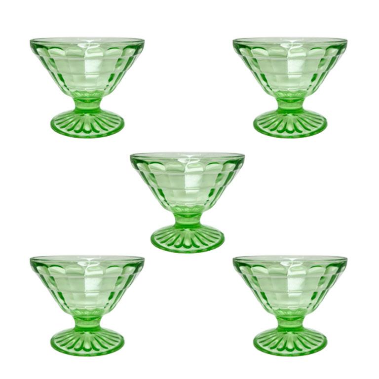 Ein Satz von fünf lindgrünen Sherbert- oder Champagner-Coupés. Diese leuchtend farbigen Gläser im unverwechselbaren Grün werden oft als Kanarienvogelglas oder Vaselineglas bezeichnet. Sie sind optisch geschliffen und auf der Innenseite facettiert,