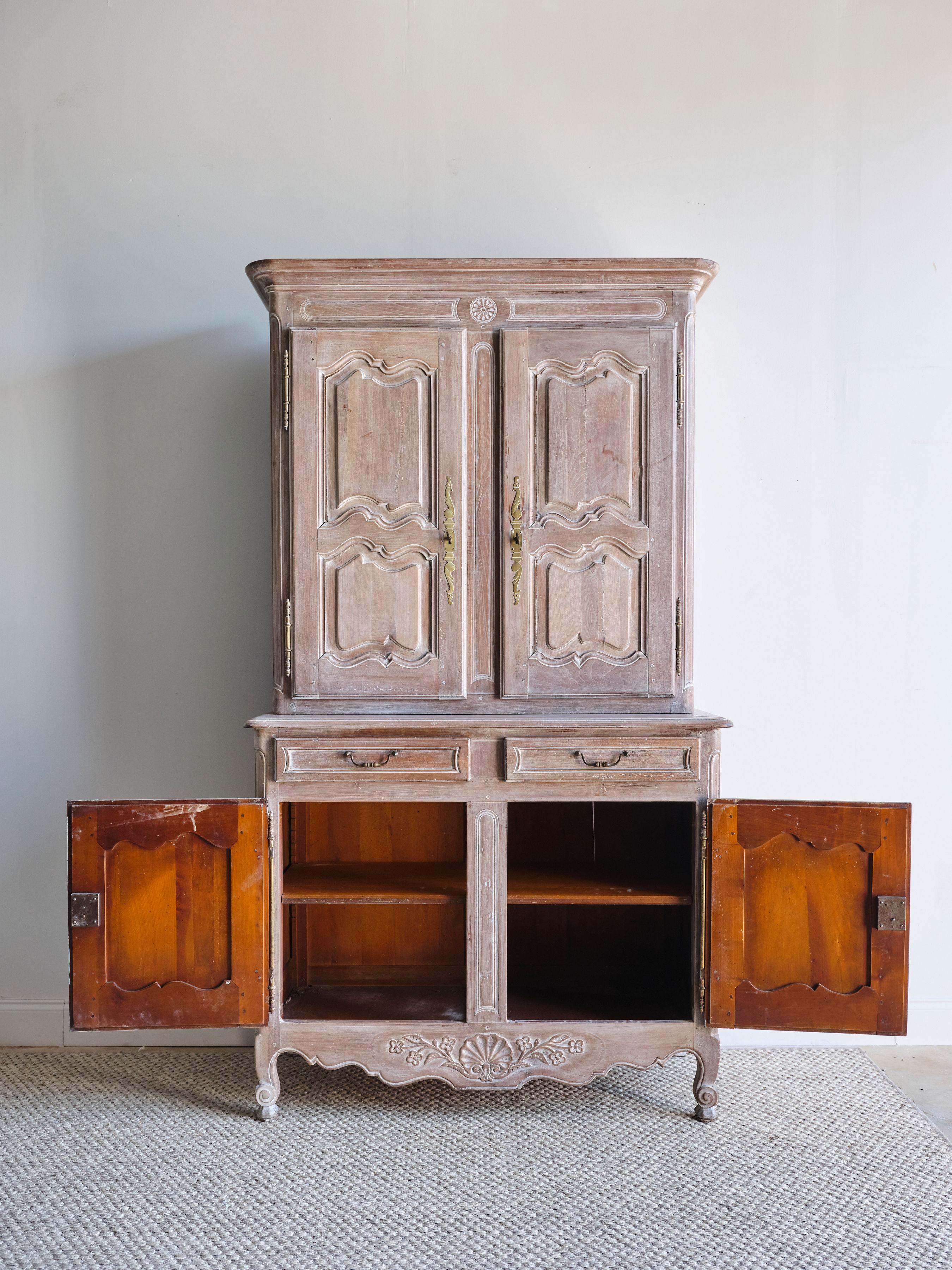 What a beautiful and unique cabinet this is! This lime washed buffet deux corps has so many lovely details that set it apart. The top part of the cabinet has two interior shelves and the bottom half has one interior shelf. This cabinet comes with