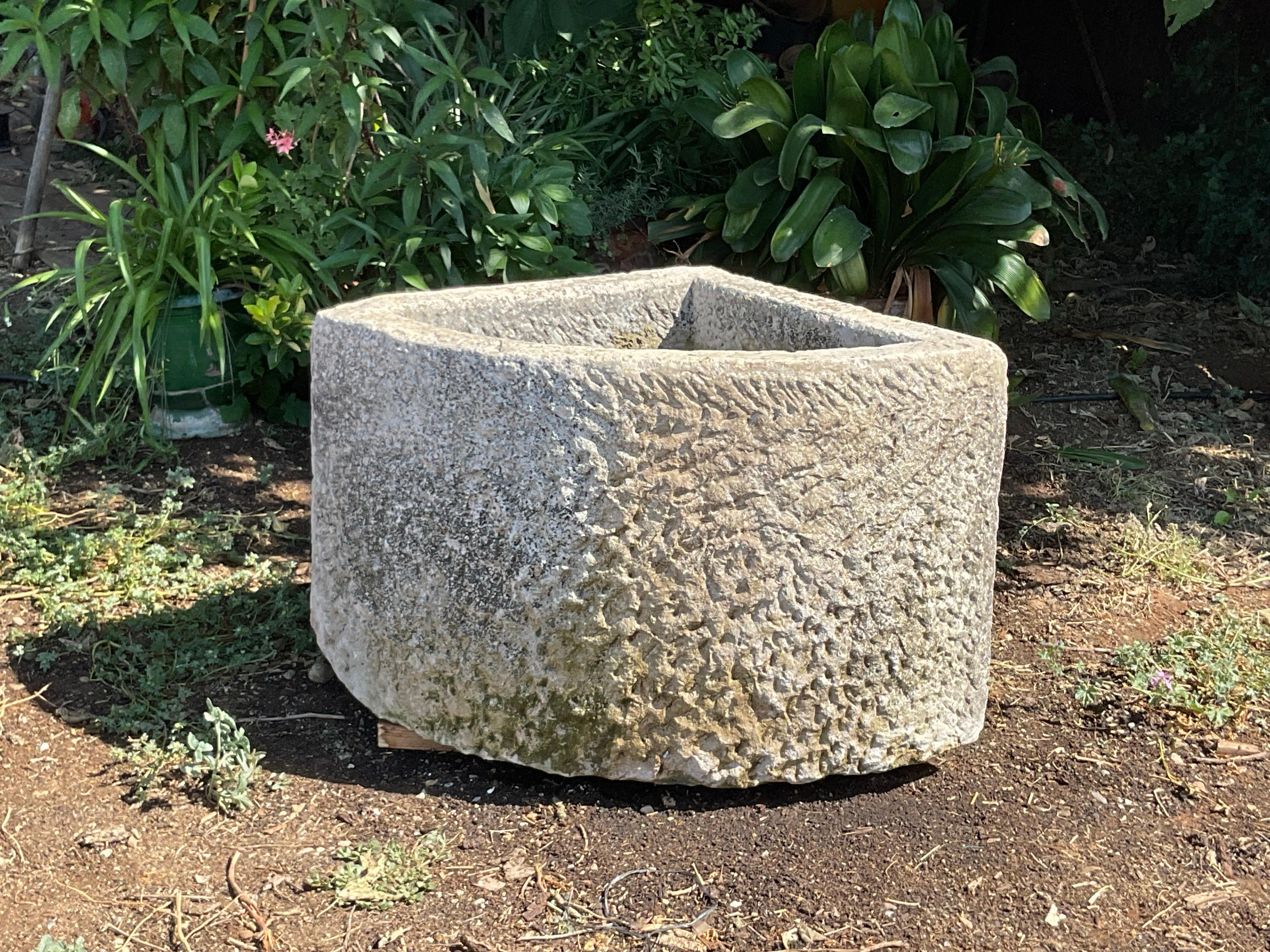 This 19th century hand-carved limestone trough from the south of France  features a triangular shape and curved front, adding 
the marks of time with its nice patina , making it attractive and an ideal choice for outdoor spaces. It can easily be