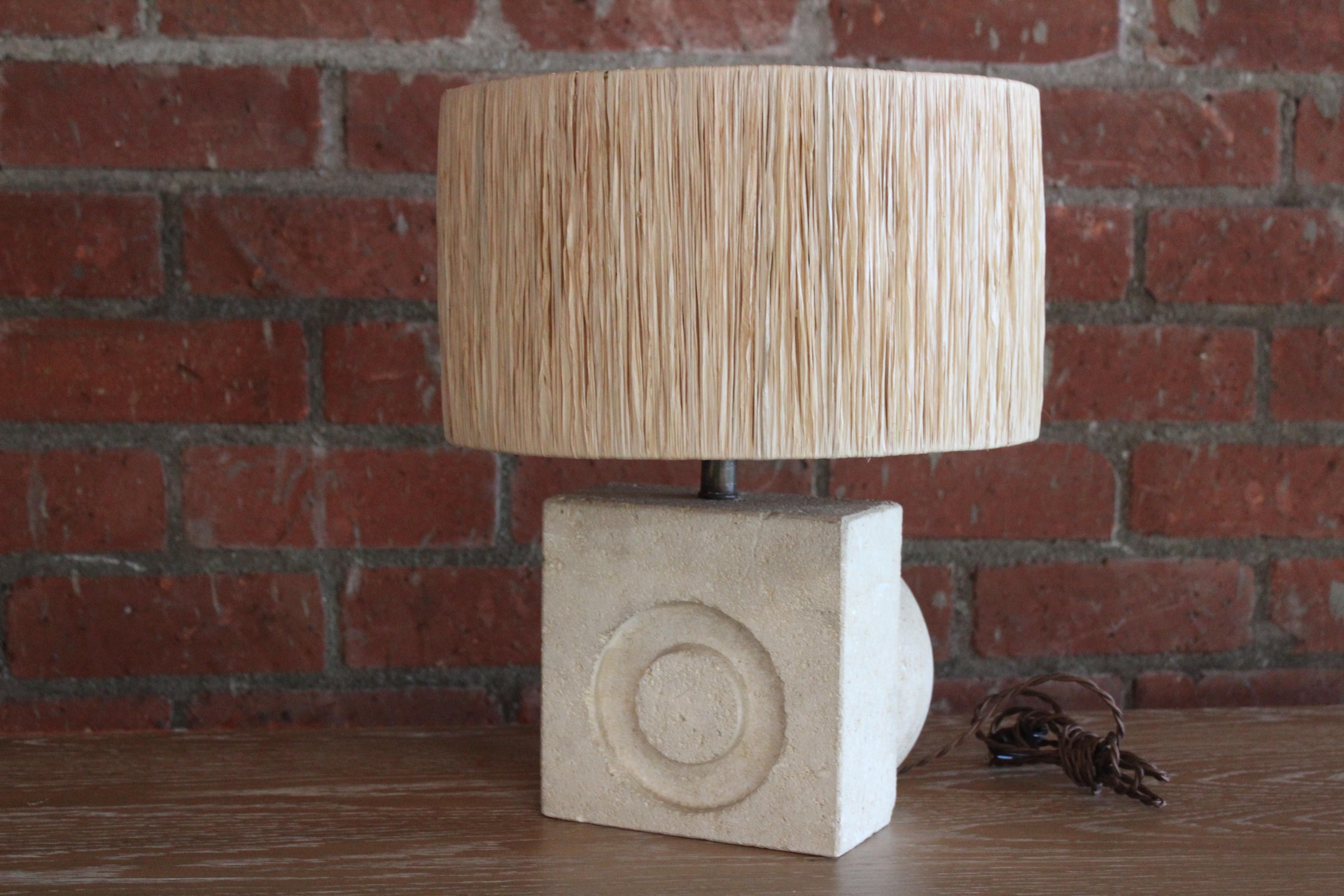 A vintage 1970s solid carved limestone lamp by Albert Tormos, France. Newly rewired and fitted with a new custom made shade in raffia. Measures: The base is 8