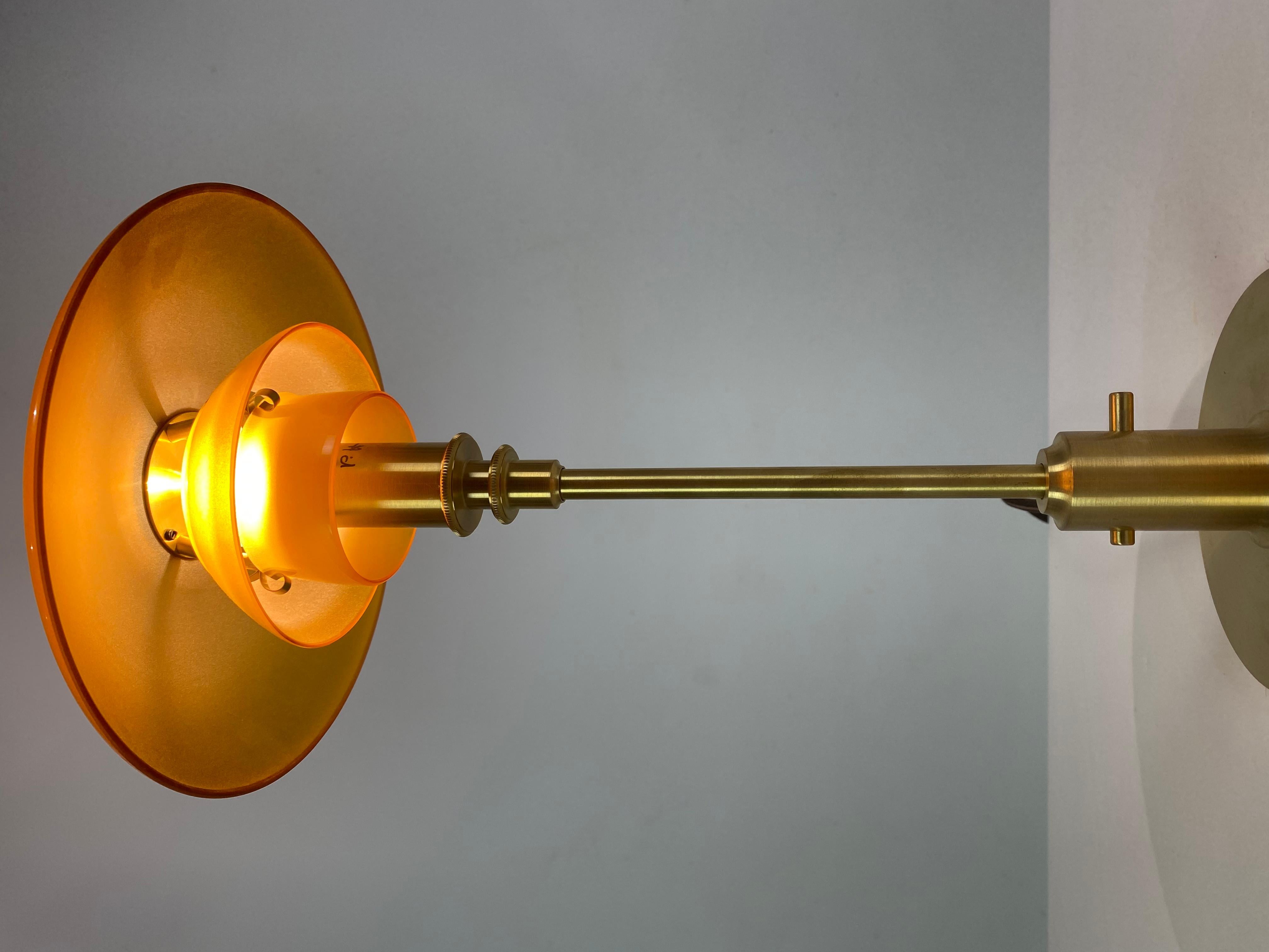 Limited edition 2018 PH 3/2 tablelamp with frame of brass and amber colored shades by Poul Henningsen and Louis Poulsen. The lamp is in very good condition. As a tribute to Poul Henningsen's ingenious work in shaping light, Louis Poulsen now