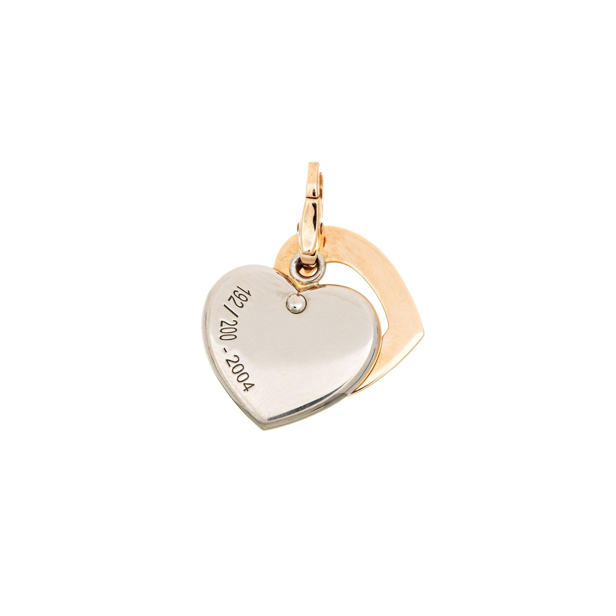 Limited edition pre-owned Cartier double heart charm (or pendant), crafted in 18 karat yellow & white gold.  

One estimated 0.03 carat round brilliant cut diamond is set into the heart (estimated at F-G color and VVS2 clarity). 
The charm is a