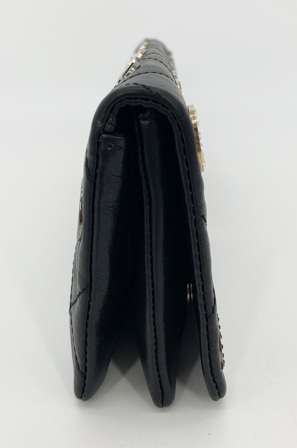 Limited Edition Chanel Black Leather Crystal Grommet Clutch in excellent condition. Black leather exterior trimmed with silver and gold various embellished metal grommets. Front flap closure opens to a black canvas interior with 2 side and 1