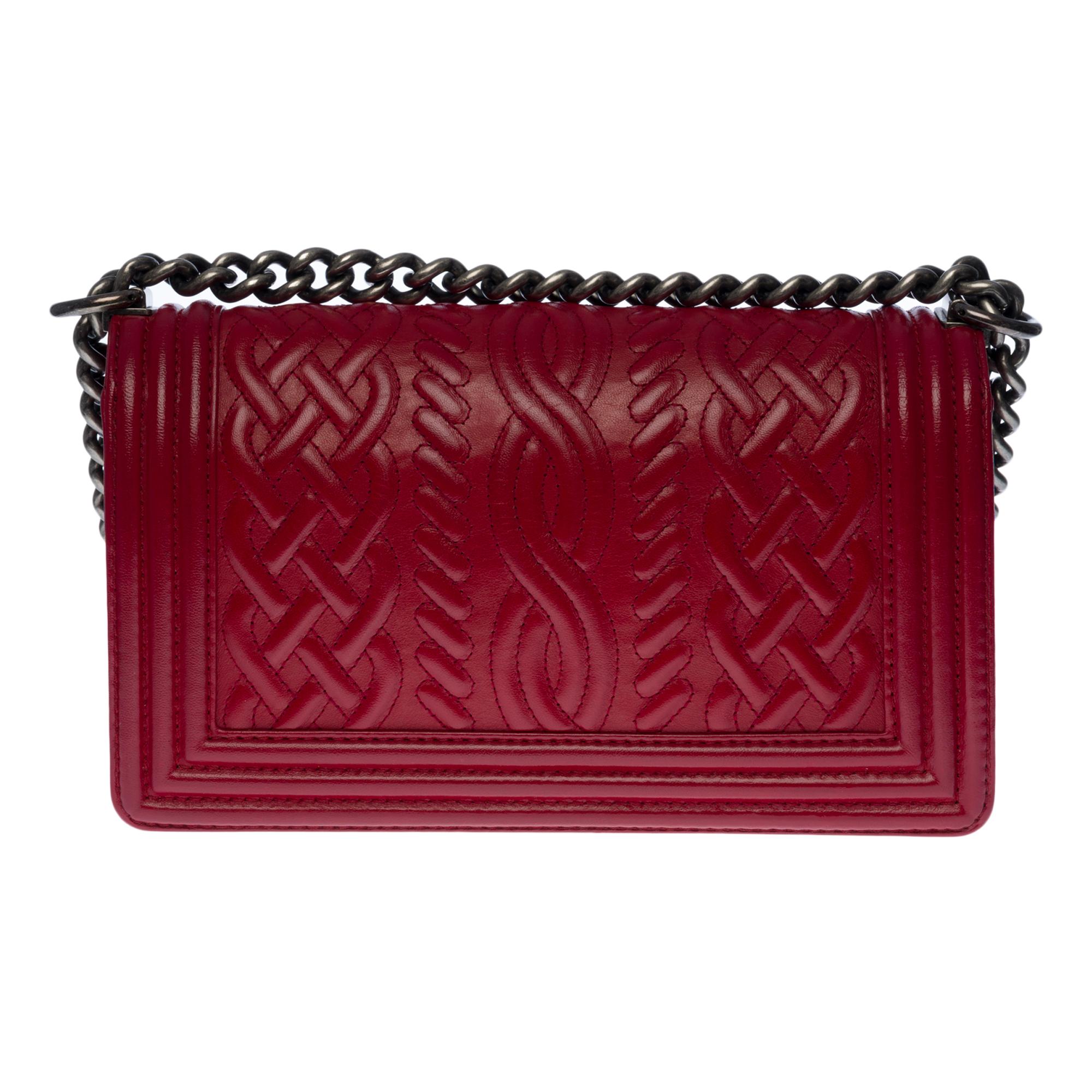 The iconic  Chanel Boy old medium limited edition shoulder bag in red embossed leather, trimmed in ruthenium metal, an adjustable ruthenium metal chain handle allowing a shoulder or shoulder strap.

A ruthenium metal logo closure on the flap.
Lining