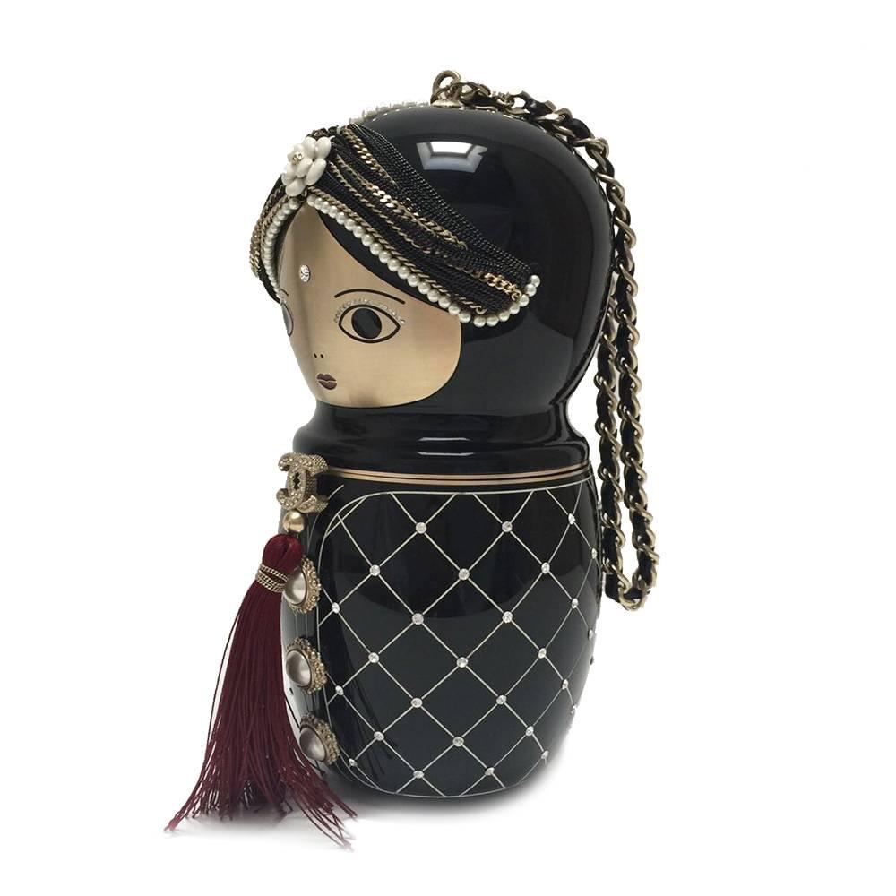 This is a Limited Edition Chanel Doll bag from the Pre-Fall 2012 Métiers d'Art Collection. Black resin Chanel Paris-Bombay Doll clutch with gold-tone and gunmetal hardware, chain-link and leather top handle, crystal embellishments throughout, pearl