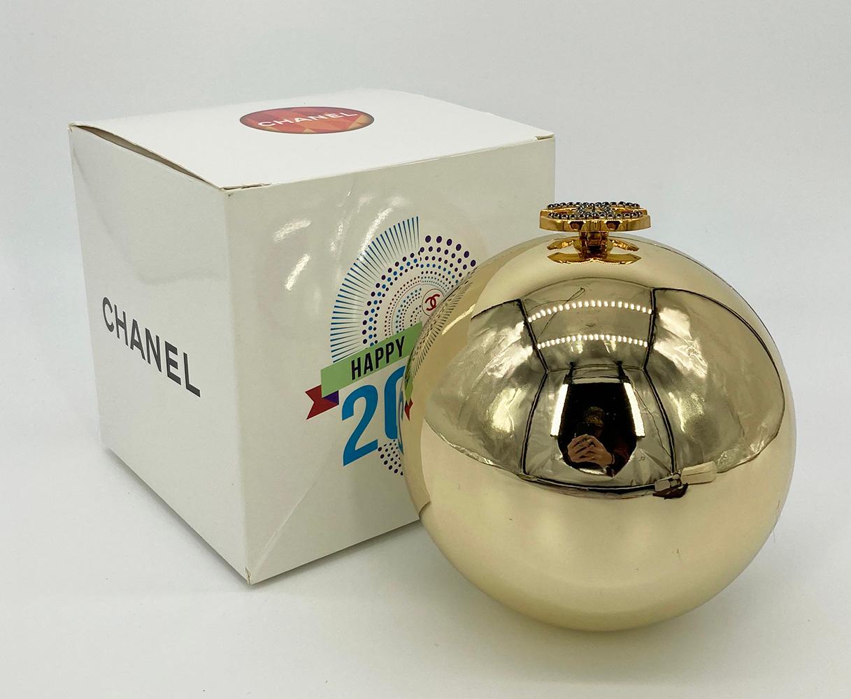 Limited Edition Chanel Beauté Gold Ball Dubai 2016 VIP Gift in fair condition. Mirrored gold exterior in unique ball shape with woven beige canvas shoulder strap with tasseled ends. Black rhinestone CC logo lifting closure opens to a gold pleather
