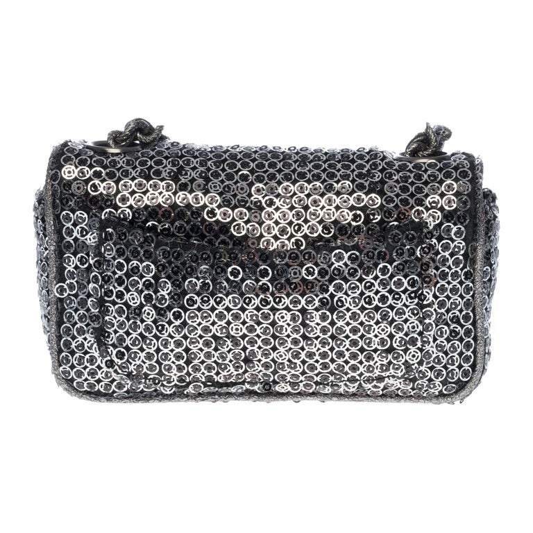 Rare limited edition Chanel Mini Flap bag in micro silver embroidered sequins, silver metal shoulder strap handle intertwined with glittery silver fabric for a shoulder or shoulder strap.
Flap closure and turnstile closure in silver metal.
Black