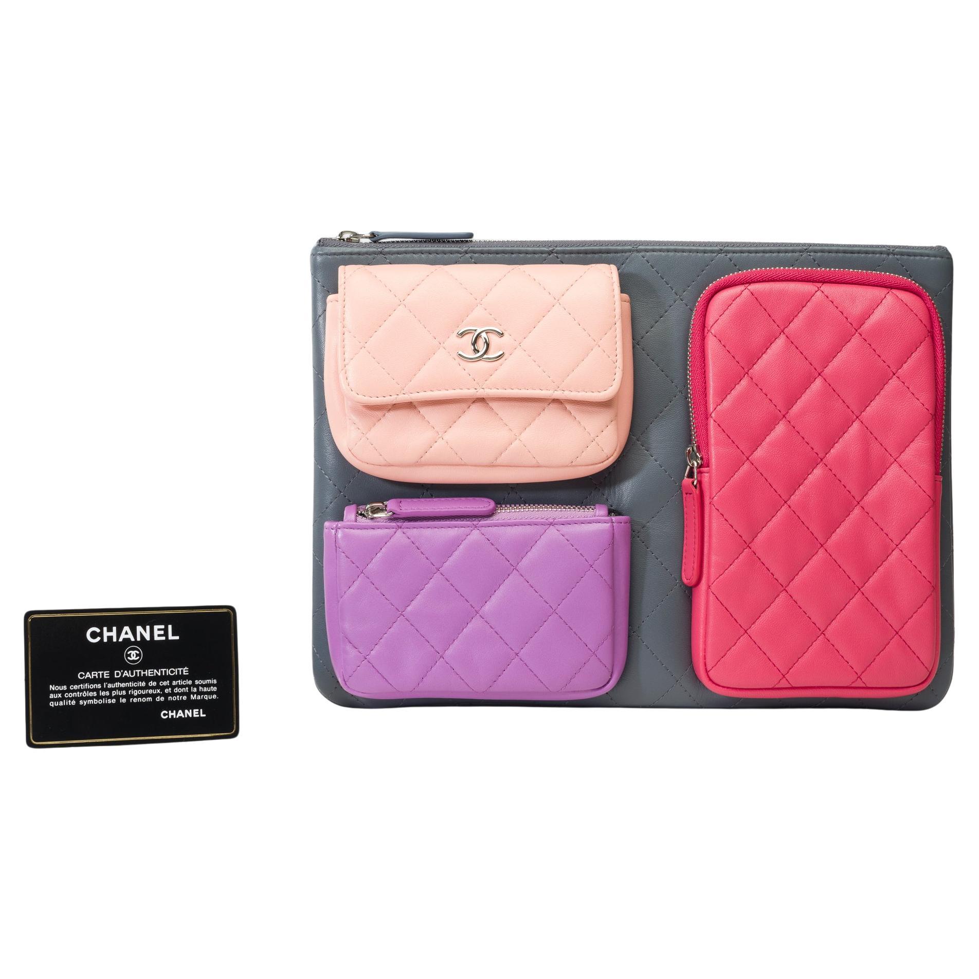 Limited​ ​Edition​ ​Chanel​ ​​ ​Pouch/Clutch​ ​in​ ​grey​ ​quilted​ ​leather​ ​with​ ​three​ ​multicolored​ ​pockets​ ​(grey,​ ​pink,​ ​purple​ ​and​ ​nude),​ ​silver​ ​metal​ ​trim​ ​for​ ​a​ ​hand​ ​carry

A​ ​patch​ ​pocket​ ​on​ ​the​ ​back​