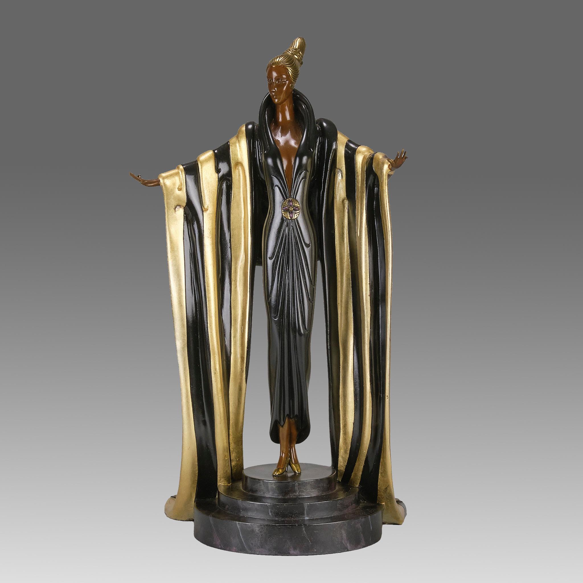 Una cautivadora figura de bronce Art Decó de edición limitada de una elegante belleza que lleva un vestido de cuerpo entero con un espectacular chal negro y dorado que le cubre los brazos y un gran medallón decorativo en la espalda. La figura se