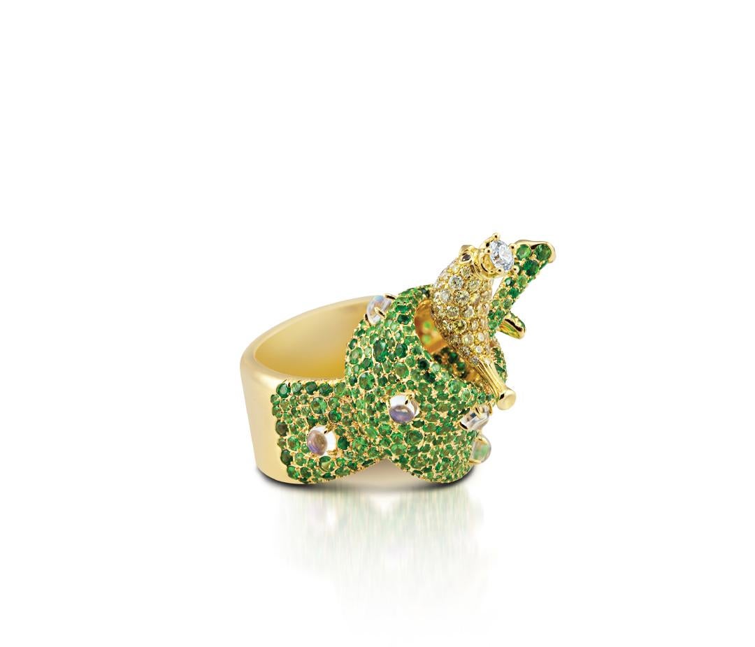 Albert Lavenda, limited edition masterpiece consisting of exquisite gemstones such us tsavorite garnet, moonstone, black, yellow and white diamonds, all set in 18K yellow gold. The motif of the ring is a crowned magpie perched upon a twisted green