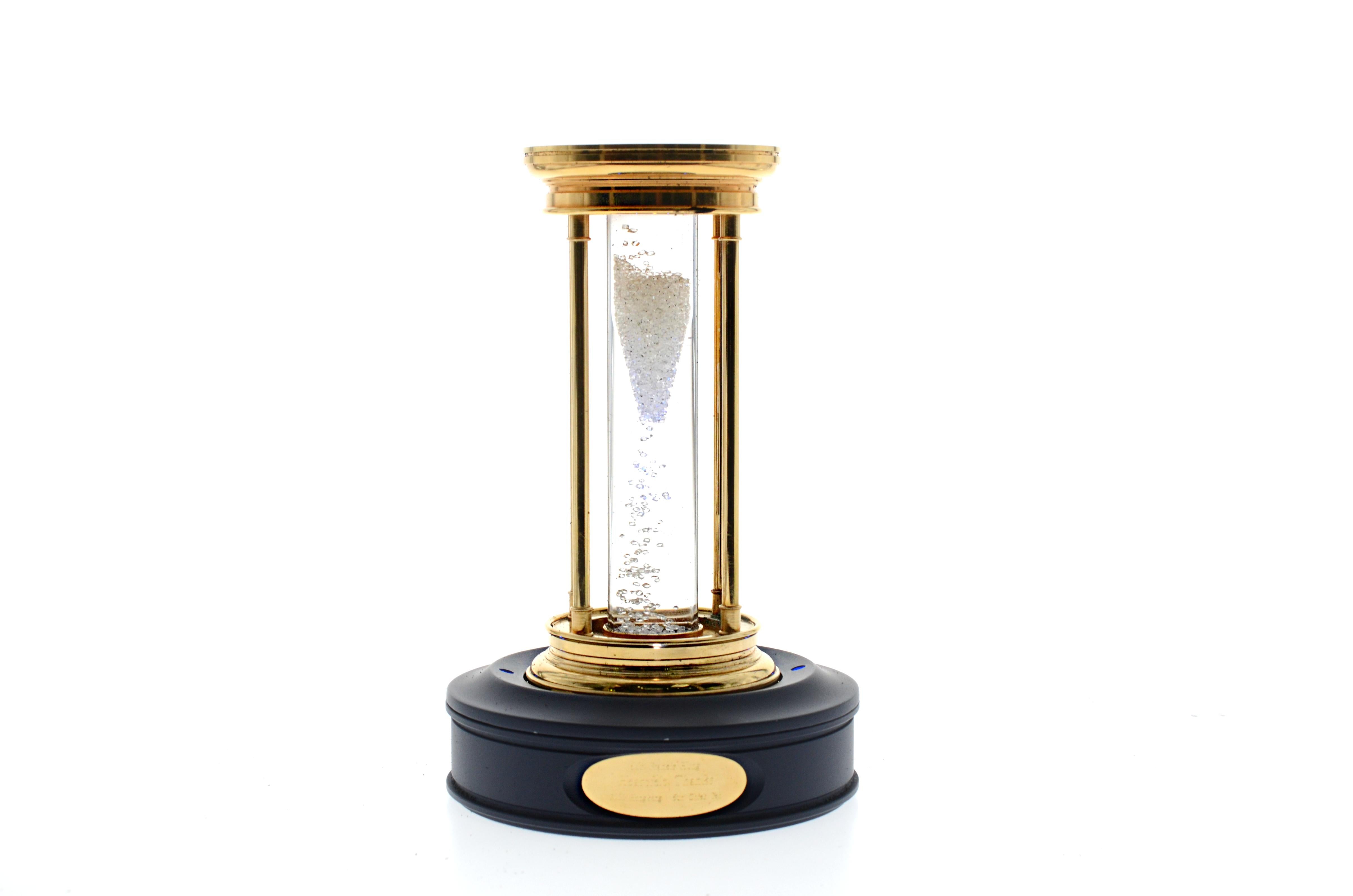 A limited edition diamond hourglass, by De Beers
Containing a cascade of over 2000 natural rough diamonds, weighing approximately 36 carats total, suspended in a silicone fluid, contained in a gold plated and acrylic reversible timer, duration