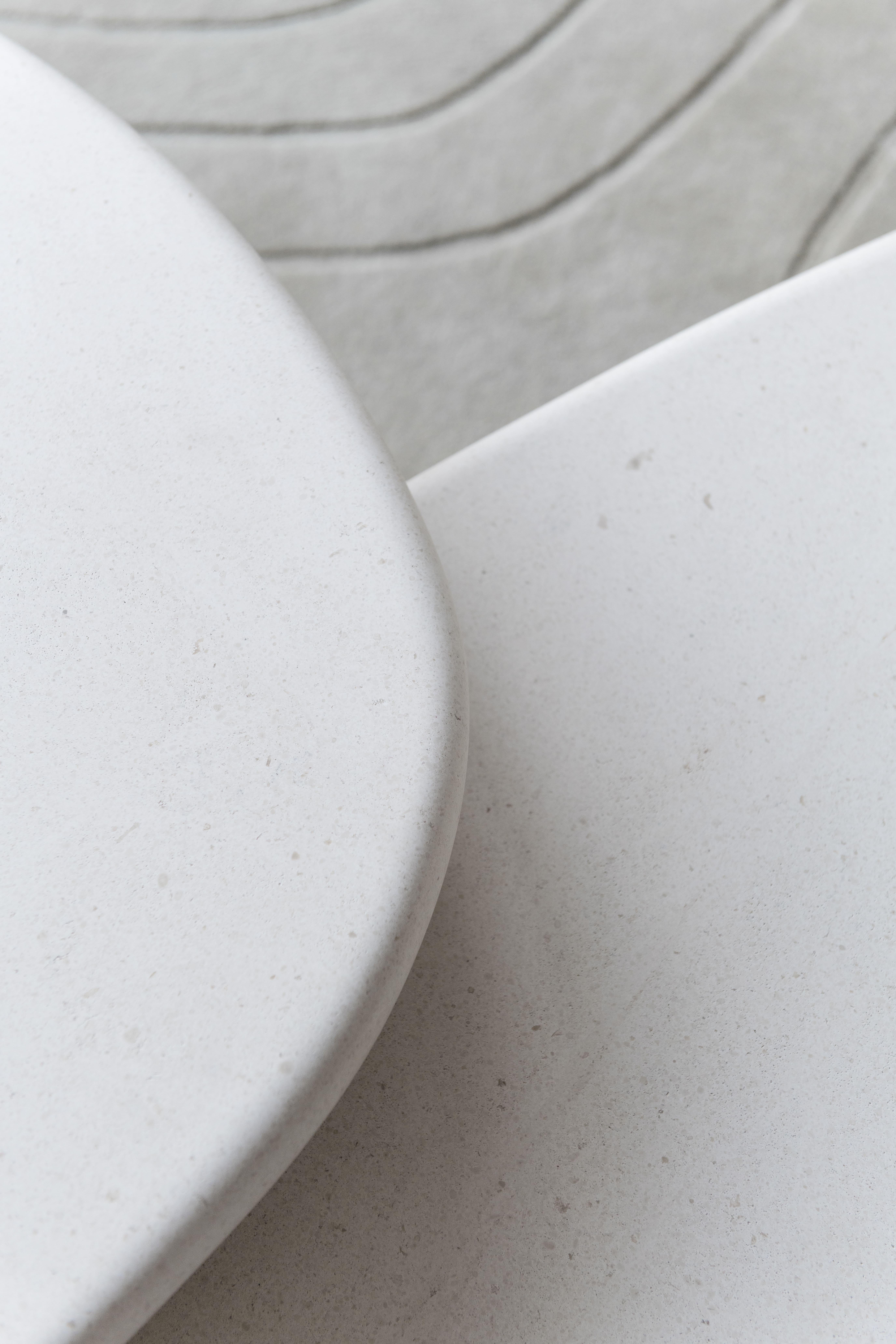 Born from the desire to turn a rigid material into a delicate, soft form, the set of coffee tables are hand-crafted entirely in capri limestone. The table tops have complementing irregular shapes and delicate tapered edges. Depending on their