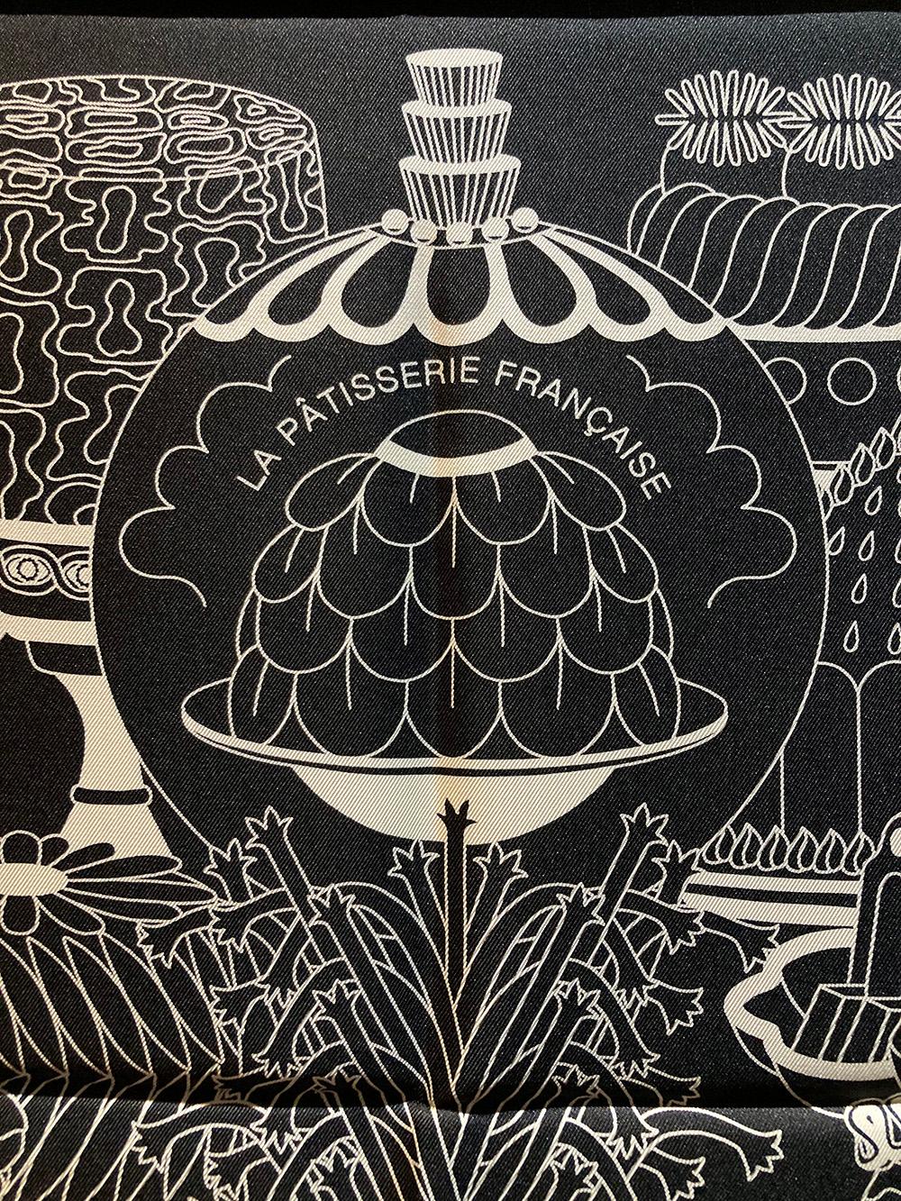 Limited Edition Hermes La Pâtisserie Française Silk Scarf in Black in excellent condition. Original silk screen design c2021 by Pierre Marie features beautiful illustrations of sweet desserts and pastries in white illustrative lines over a solid