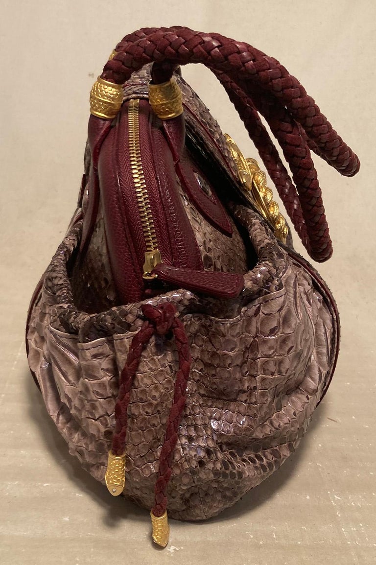 Limited Edition Judith Leiber Rachel Zoe Python Medusa Bag in very good condition. Purple python exterior trimmed with maroon leather, matte gold hardware and elastic side pockets. Double braided top shoulder straps. Unique gold embellished front