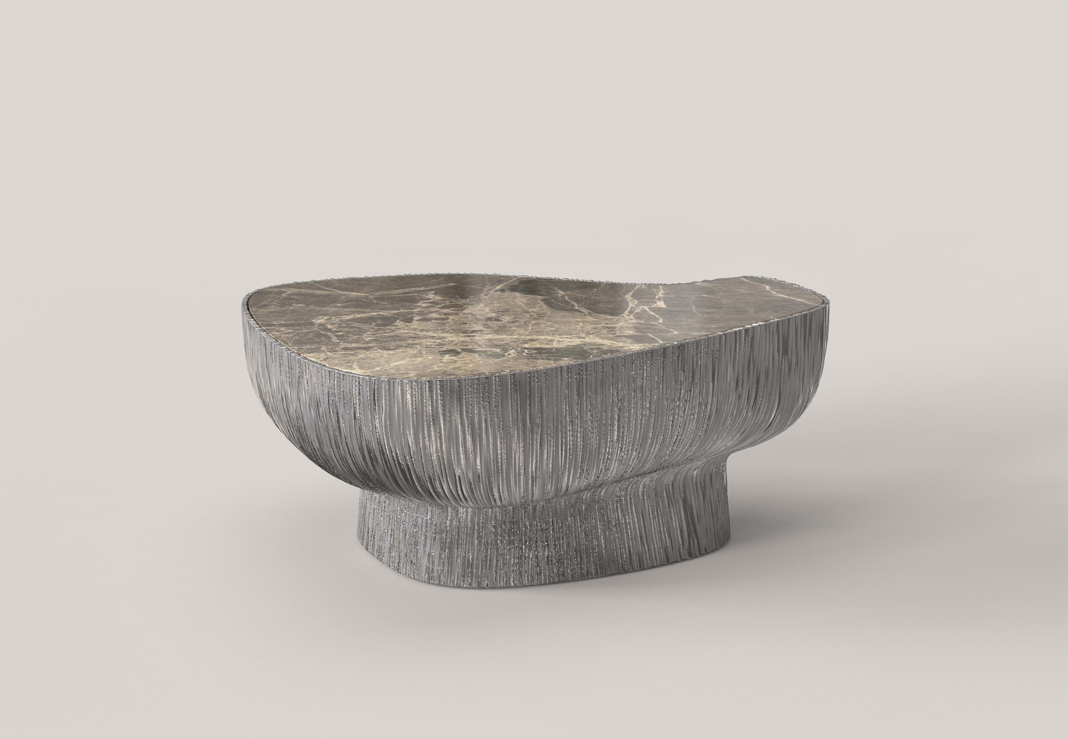 Giava V2 ist ein niedriger Tisch des 21. Jahrhunderts aus Aluminiumguss mit einer außergewöhnlichen Marmorplatte aus Breccia Paradiso. Der Aluminiumguss zeichnet sich durch eine skulpturale Oberfläche mit einer Riffelung aus, die ihm eine