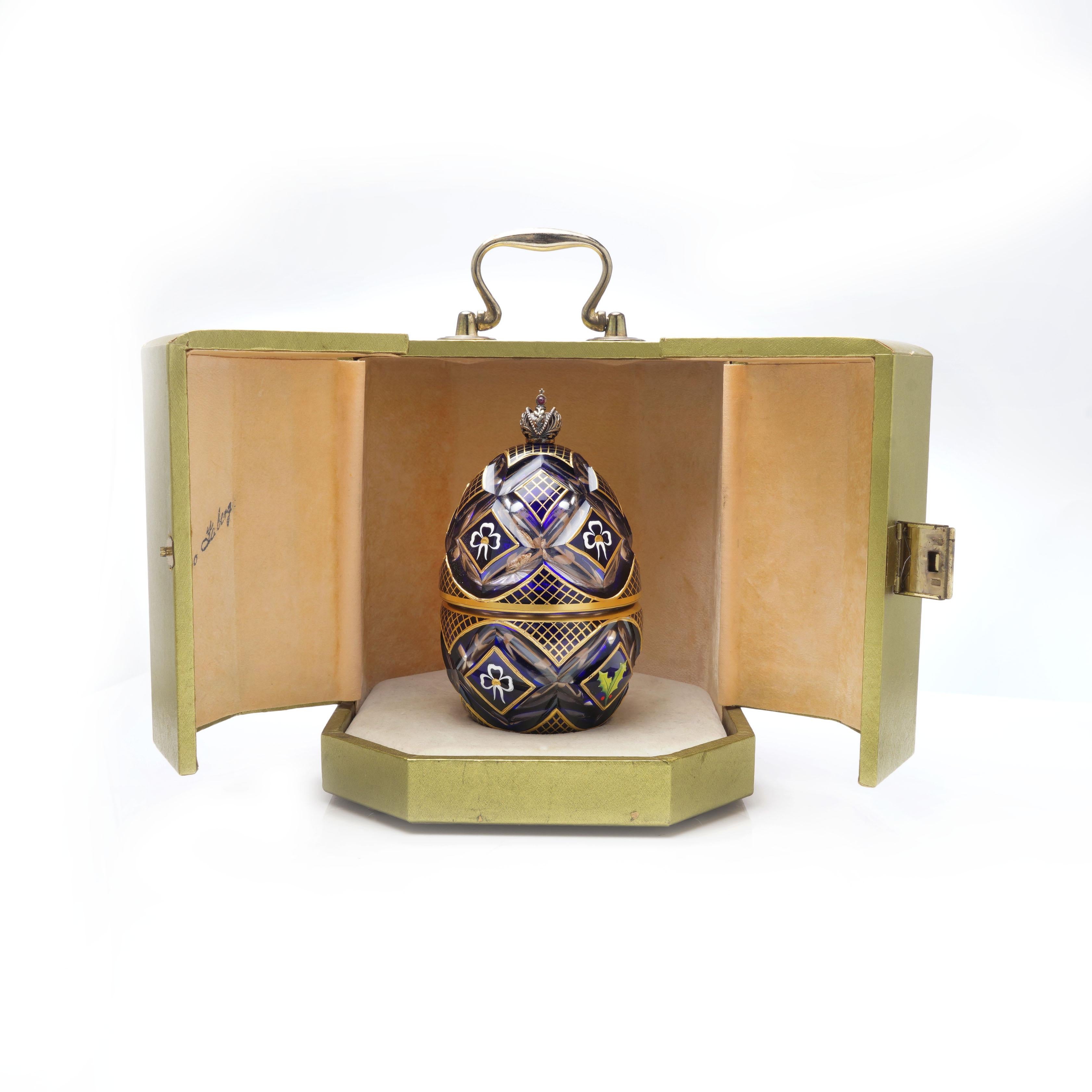 Limited edition Nr.124 The winter egg music box by Theo Faberge.

The winter egg is a celebration of Christmas and the winter season.
Made of cobalt blue and clear crystal and set with the Imperial Crown of Russia.
Delicate bows and holly