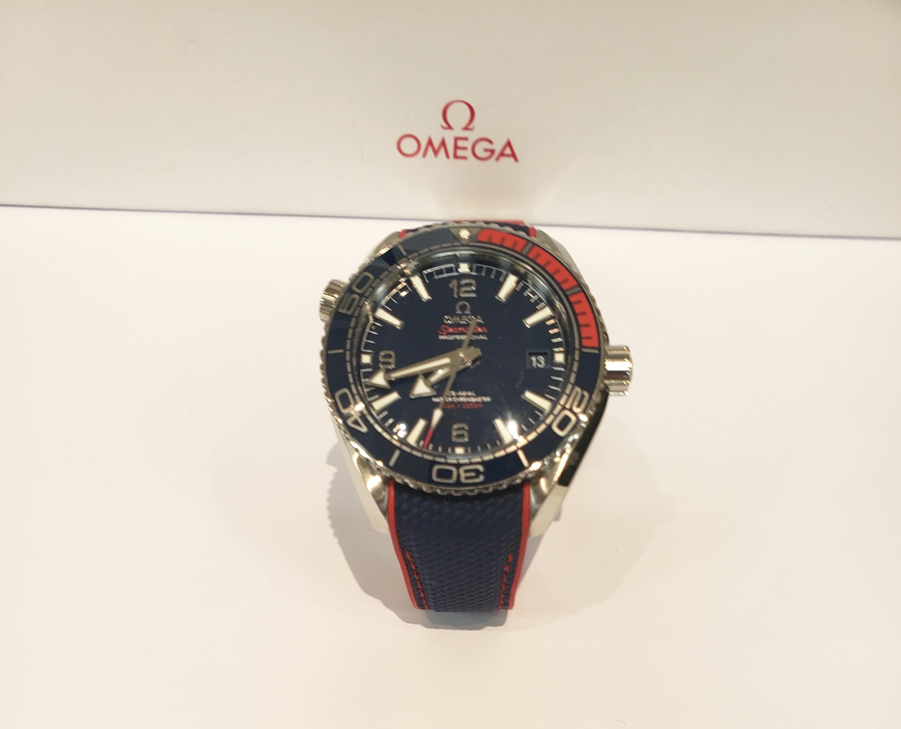 A Commemorative Limited Edition Omega Sea Master Planet Ocean 2018 Olympic Games Watch. 43.5 Millimeter, Stainless Steel Case With Blue Dial With Red Accents. Automatic Movement. Co-Axial Master Chronometer. Skeleton Back. Water Resistant To 200