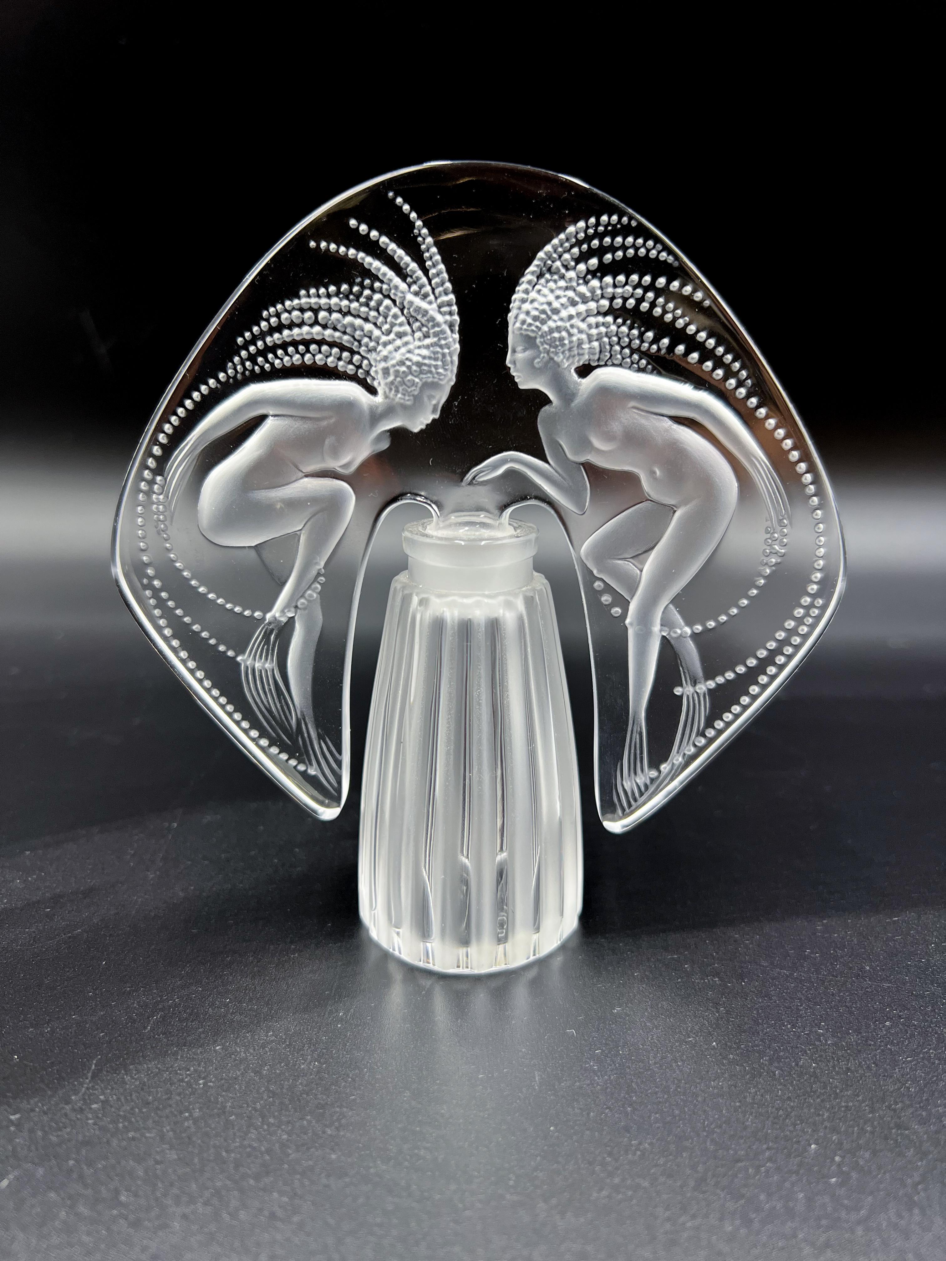 A stunning French Limited edition crystal glass flacon with a large fan-shaped stopper decorated with an engraved design of two sirens with wonderful depth and detail signed Lalique France and numbered to base.


Ondines
The 1998 Limited Edition
