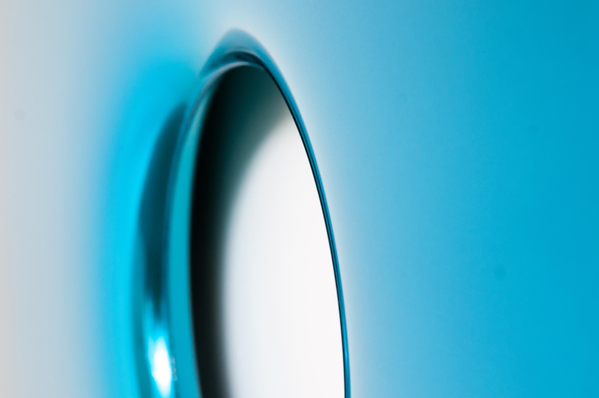 Limited edition mirror in space blue made of polished stainless steel.