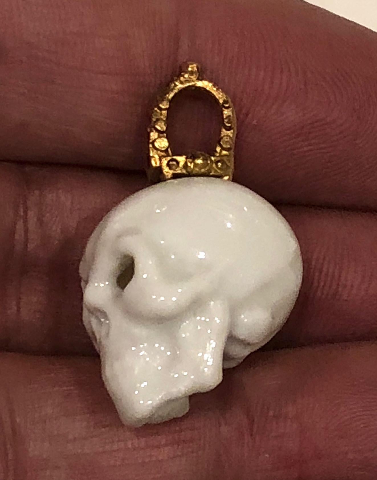 Skull pendant in Rosenthal porcelain with 18k gold and set rubies.
Stamped