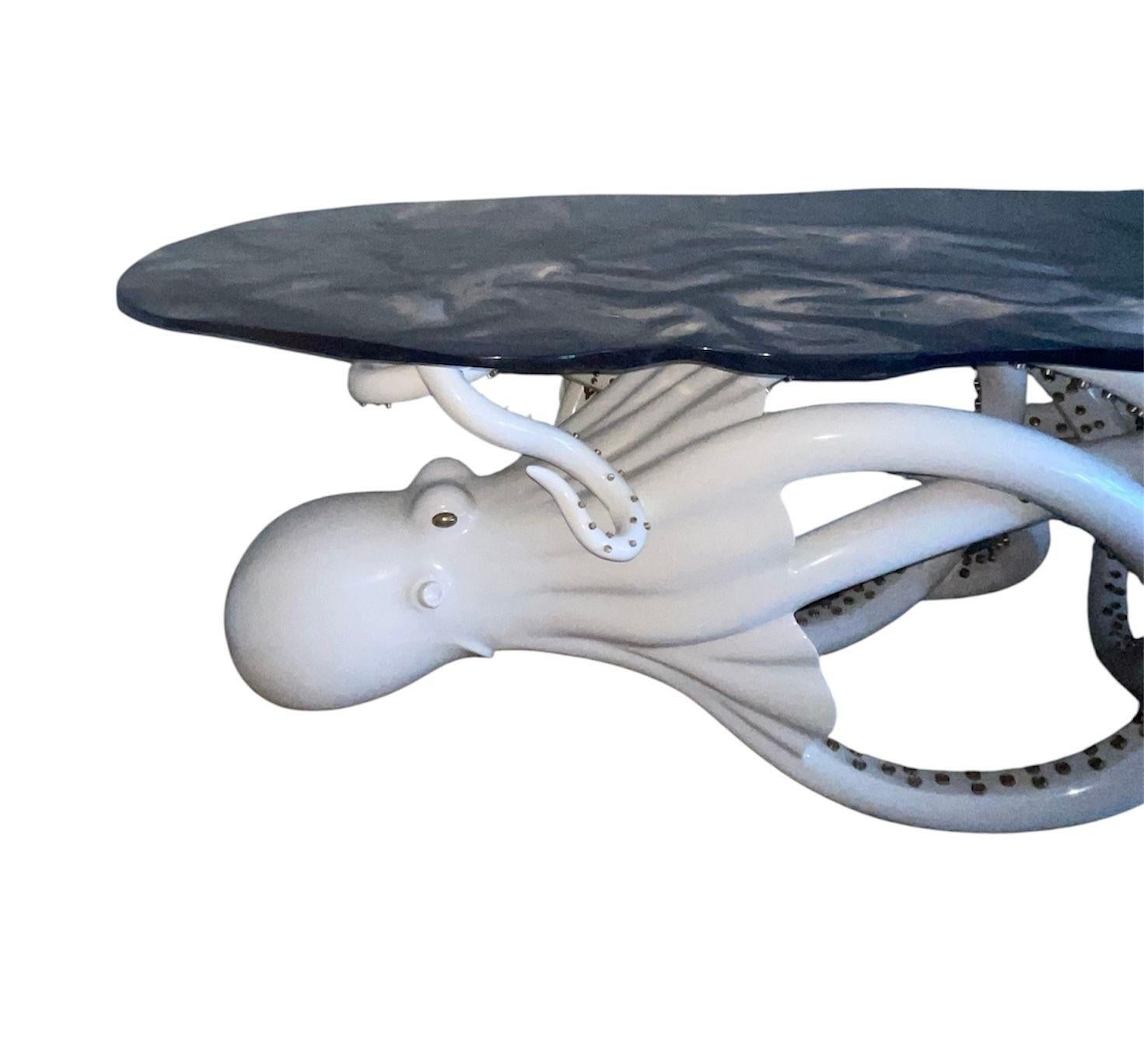 A striking and imaginative limited-edition sculptural console table, masterfully designed to merge functional furniture with artistic expression. The base features a life-like octopus rendered in a cream high-gloss finish, its flowing tentacles