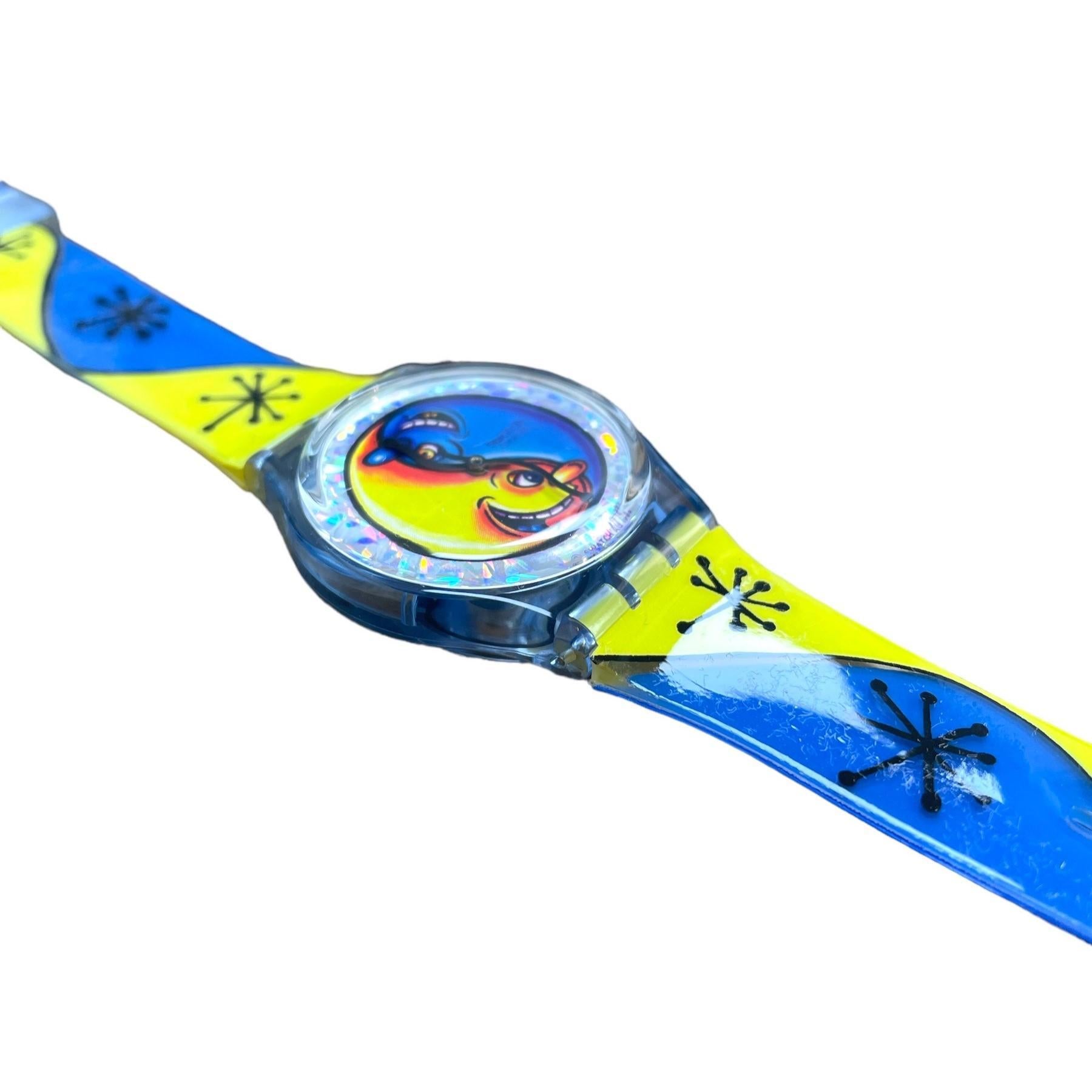 Elevate your style with this iconic limited edition Swatch Fiz N'Zip designed by the renowned artist Kenny Scharf. A true collector's item from the 1990s, this unworn timepiece boasts both artistic flair and precision engineering.

Display: