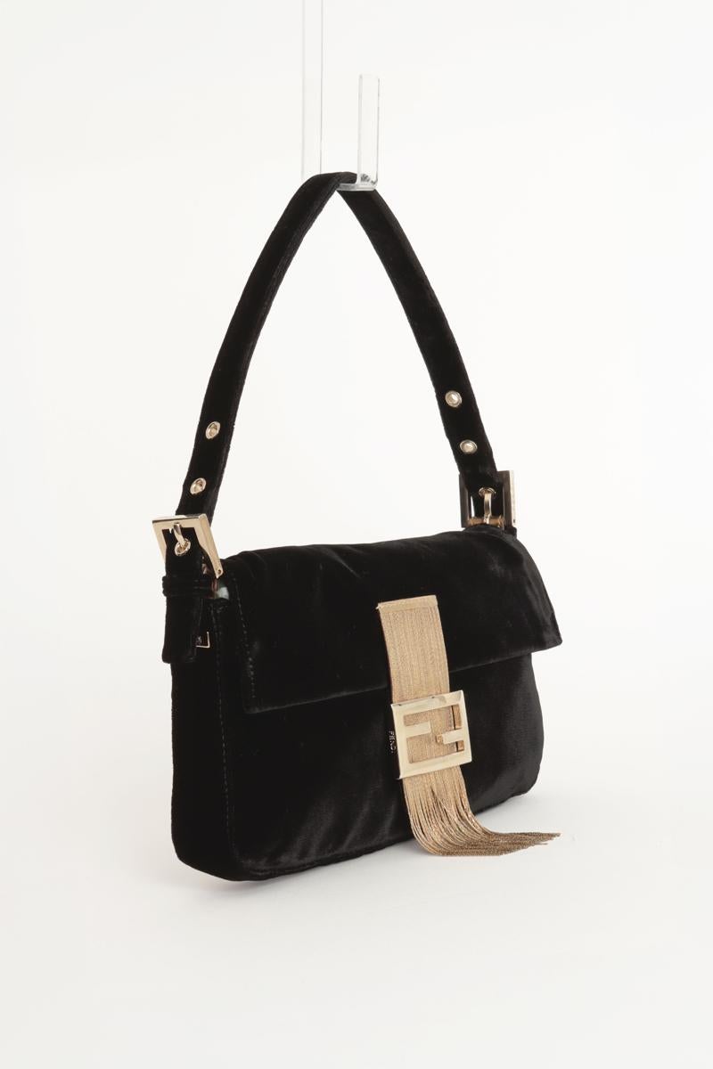 Borsa Fendi Baguette vintage in velluto nero in edizione limitata con chiusura a doppia F dorata e frange. Chiusura con patta e fibbia FF in metallo dorato, decorata con frange metalliche. Tracolla regolabile in velluto con dettagli dorati incisi.