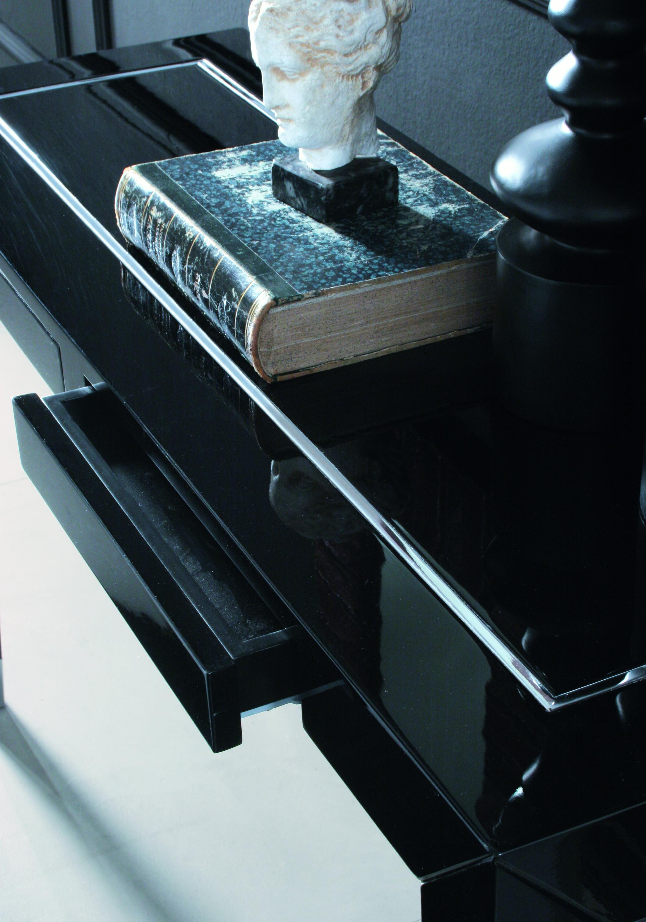 Console en bois Orson avec détail chromé poli incrusté sur le plateau, n°2 tiroirs, caches chromés polis et finition noire laquée brillante.