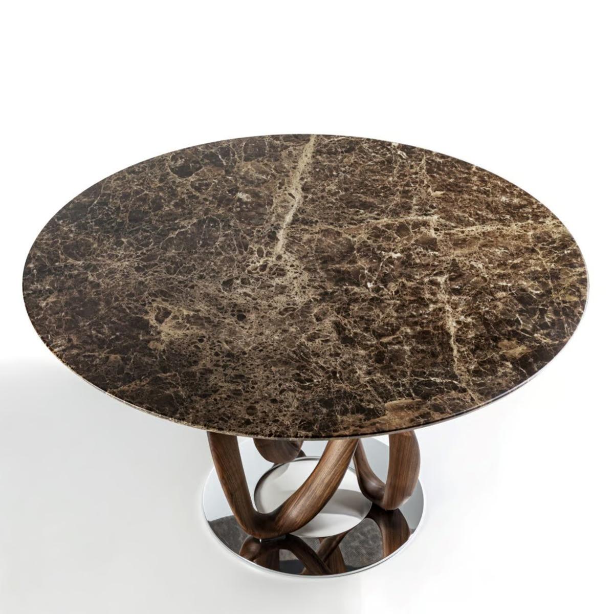 Mesa de comedor Limitless Mármol con base de madera maciza de nogal
sobre anillo base de acero en acabado cromado. Con emperador pulido
Encimera de mármol, 20 mm de grosor.
También disponible bajo pedido con base de nogal macizo teñido en
acabado