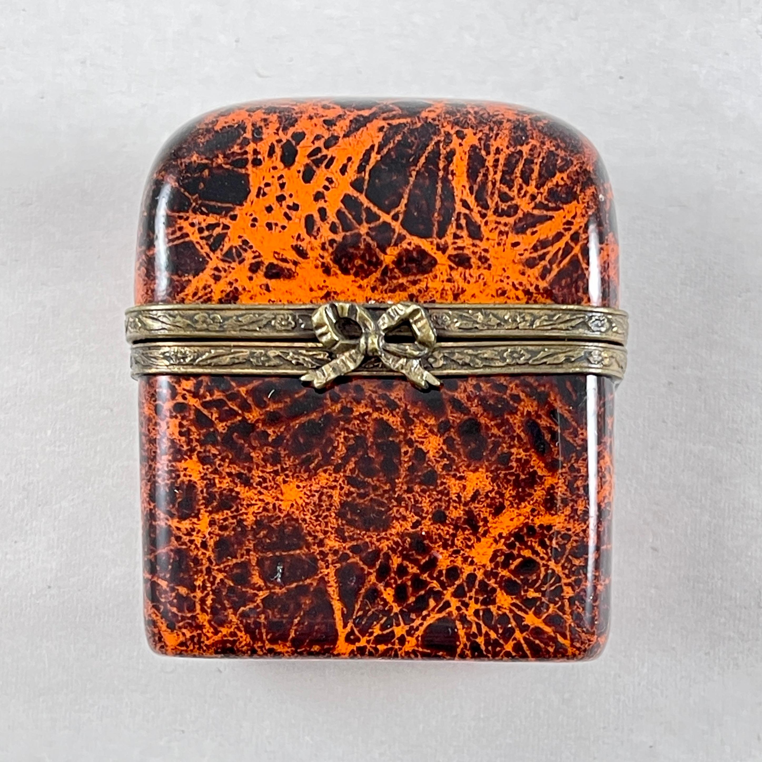 De Limoges, Francia, una caja de baratijas esmaltada a mano, un cofre de perfumes con dos frascos de cristal, hacia los años 1970-1980.

El baúl de metal reforzado tiene una tapa abovedada y está pintado con un acabado de imitación de caparazón de