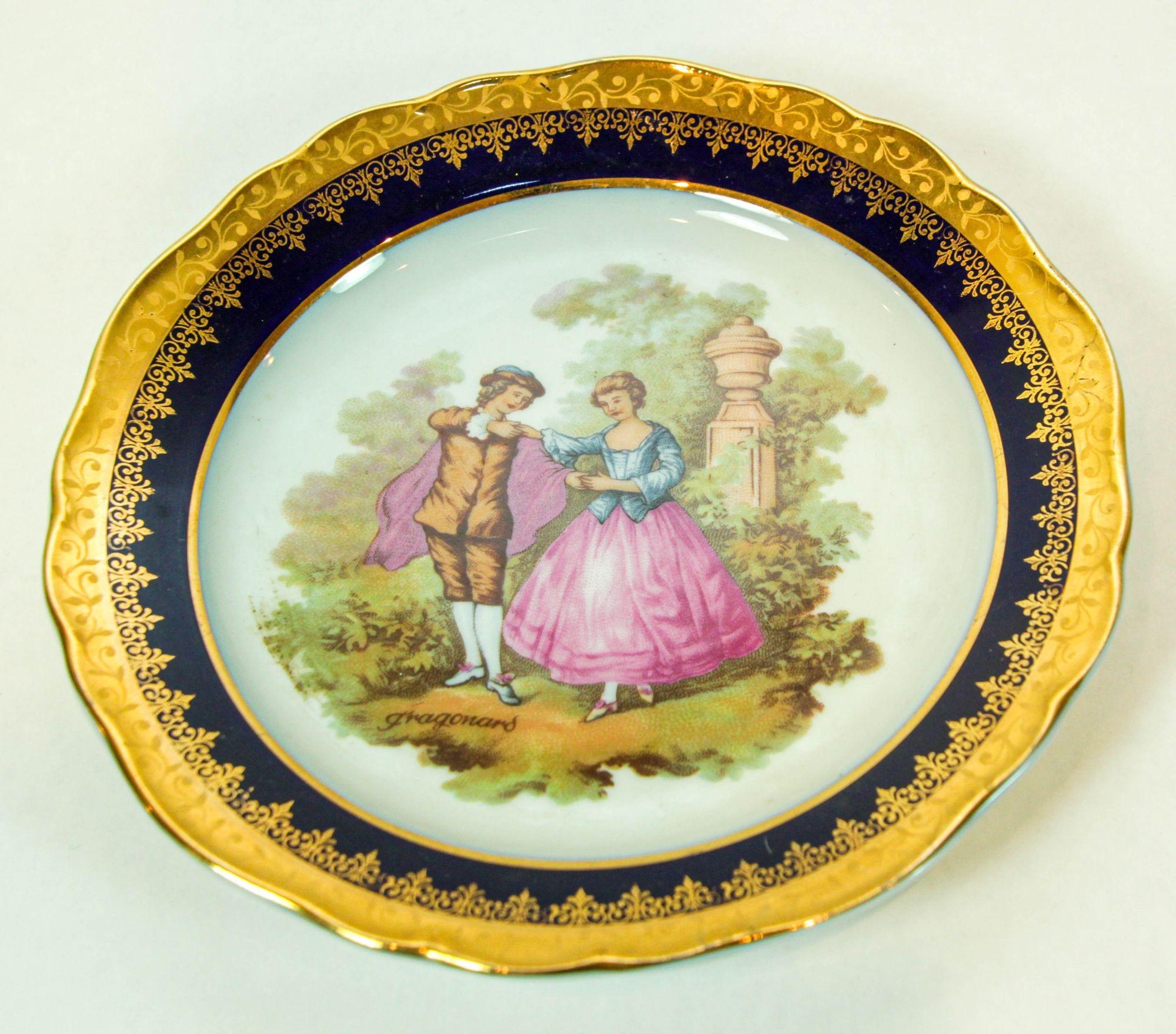 Vintage limoges Francia fina porcelana redonda decorativa azul y oro.
Elegante plato decorativo de porcelana fina pintado a mano con una romántica escena de amantes en un jardín, azul real cobalto y rico dorado en toda la superficie, según la