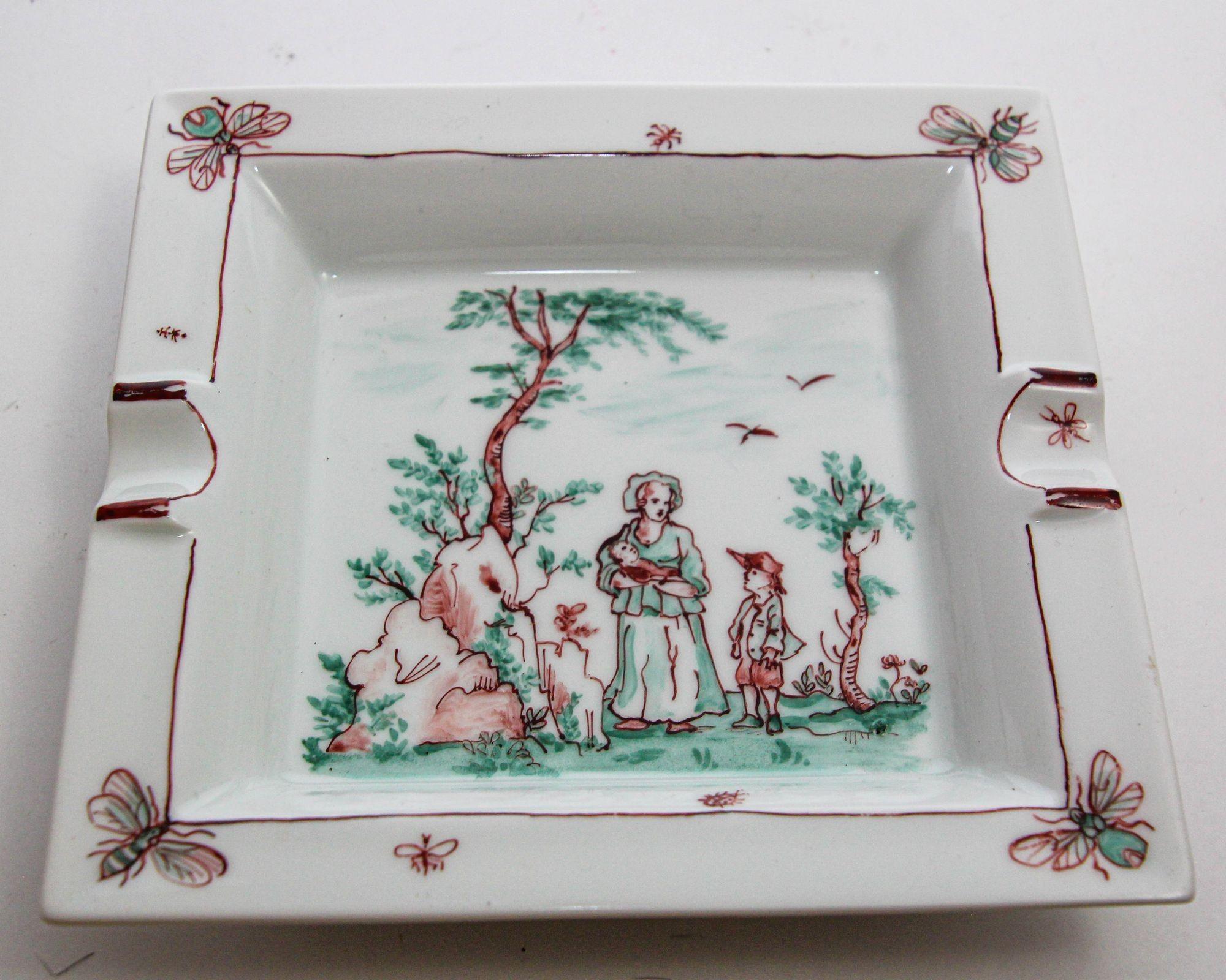 Large one of a kind Limoges porcelain ashtray in a square shape featuring a beautiful hand painted country scene from the 19th century depicting a lady with a baby in her hands and another kid in period dresses in a garden with bees, butterflies,